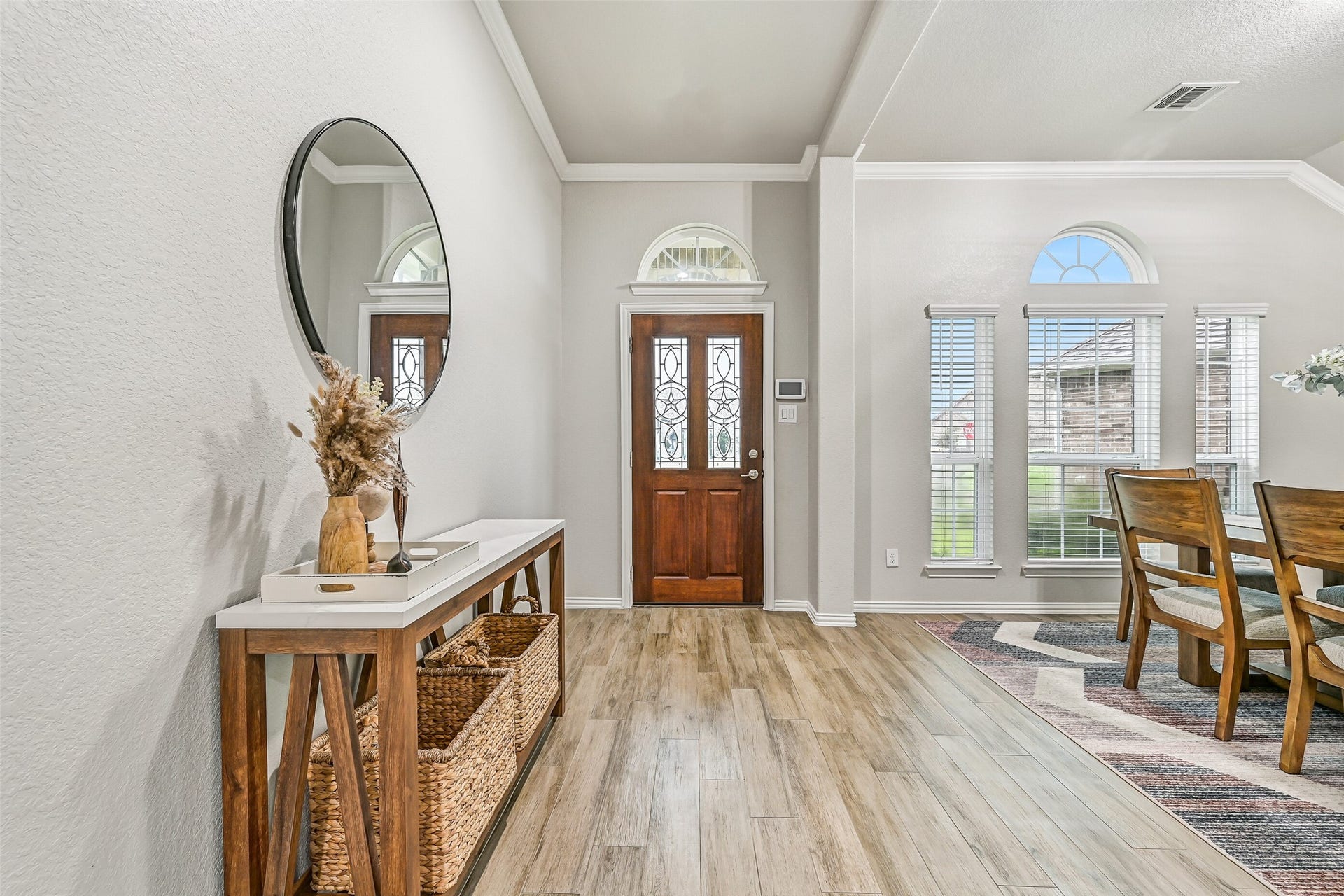 Looking back toward the entry, you'll appreciate the abundance of natural light pouring through the transom window and tall front windows. Crown molding and updated finishes create a clean, move-in-ready first impression.