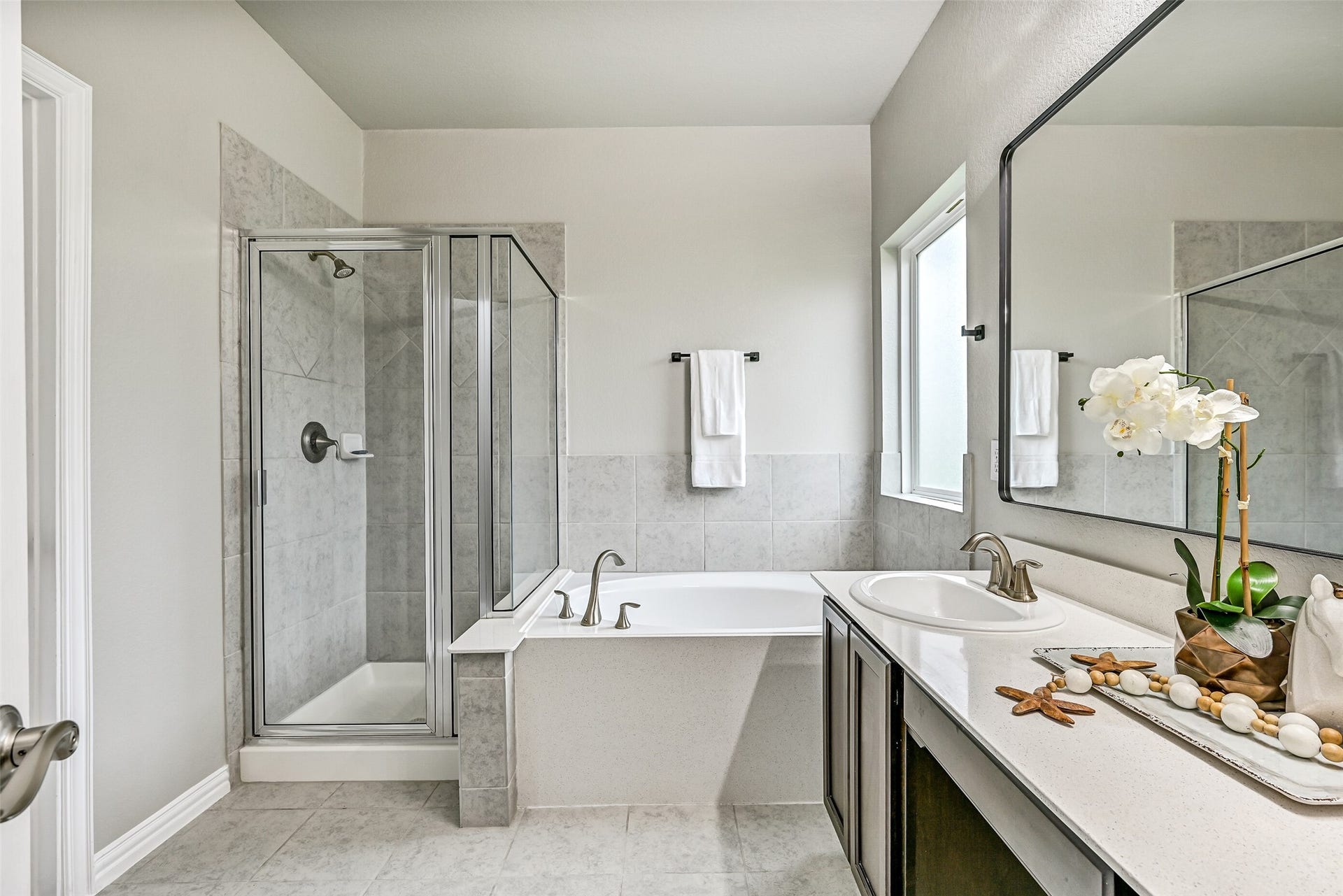 Designed for relaxation, the primary bath also includes a soaking tub, separate glass-enclosed shower, and private water closet. Thoughtful finishes and a functional layout create a comfortable space to begin and end each day.