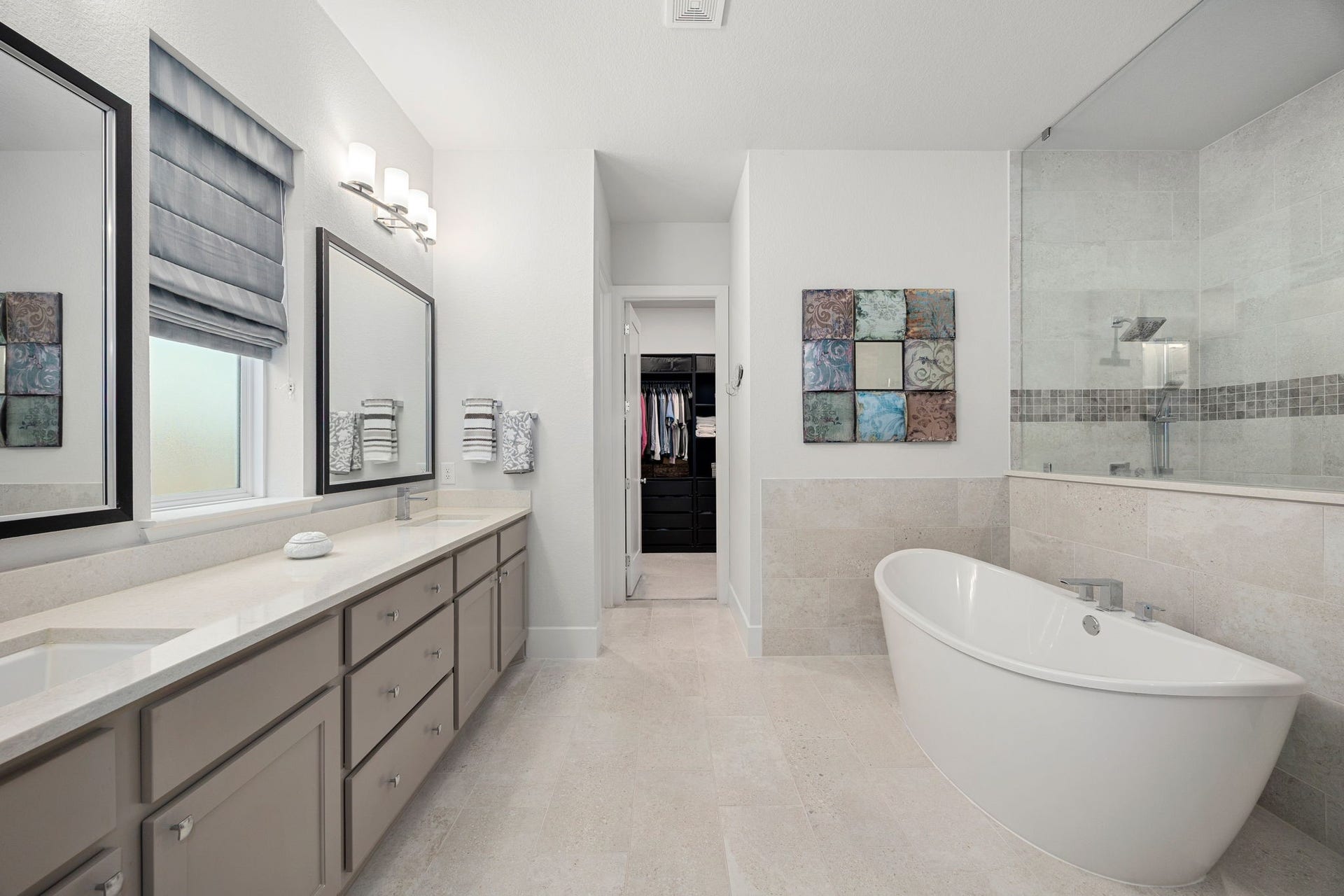 18 Gentle Branch Place, The Woodlands, TX 77375 Indulge in a spa-like experience in this luxurious primary bath, featuring a deep freestanding soaking tub and an expansive glass-enclosed walk-in shower. A massive double vanity with sleek stone countertops and modern designer lighting completes this bright, airy sanctuary.