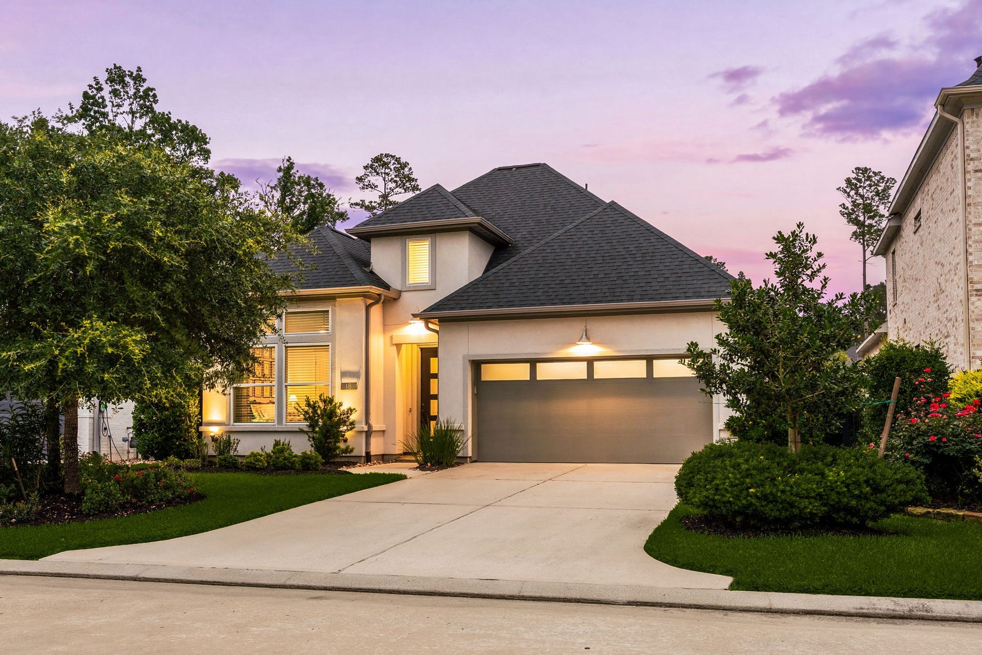 18 Gentle Branch Place, The Woodlands, TX 77375 Welcome to 18 Gentle Branch Place, ideally situated on a quiet cul-de-sac in The Woodlands Creekside Park and zoned to Tomball ISD. This stunning modern residence offers timeless curb appeal with a beautifully manicured lawn, lush professional landscaping, elegant stucco elevation, and a striking dark-stained front door with sophisticated glass detailing. A charming covered front porch and private double-wide driveway complete the impressive exterior, creating a warm yet refined first impression.