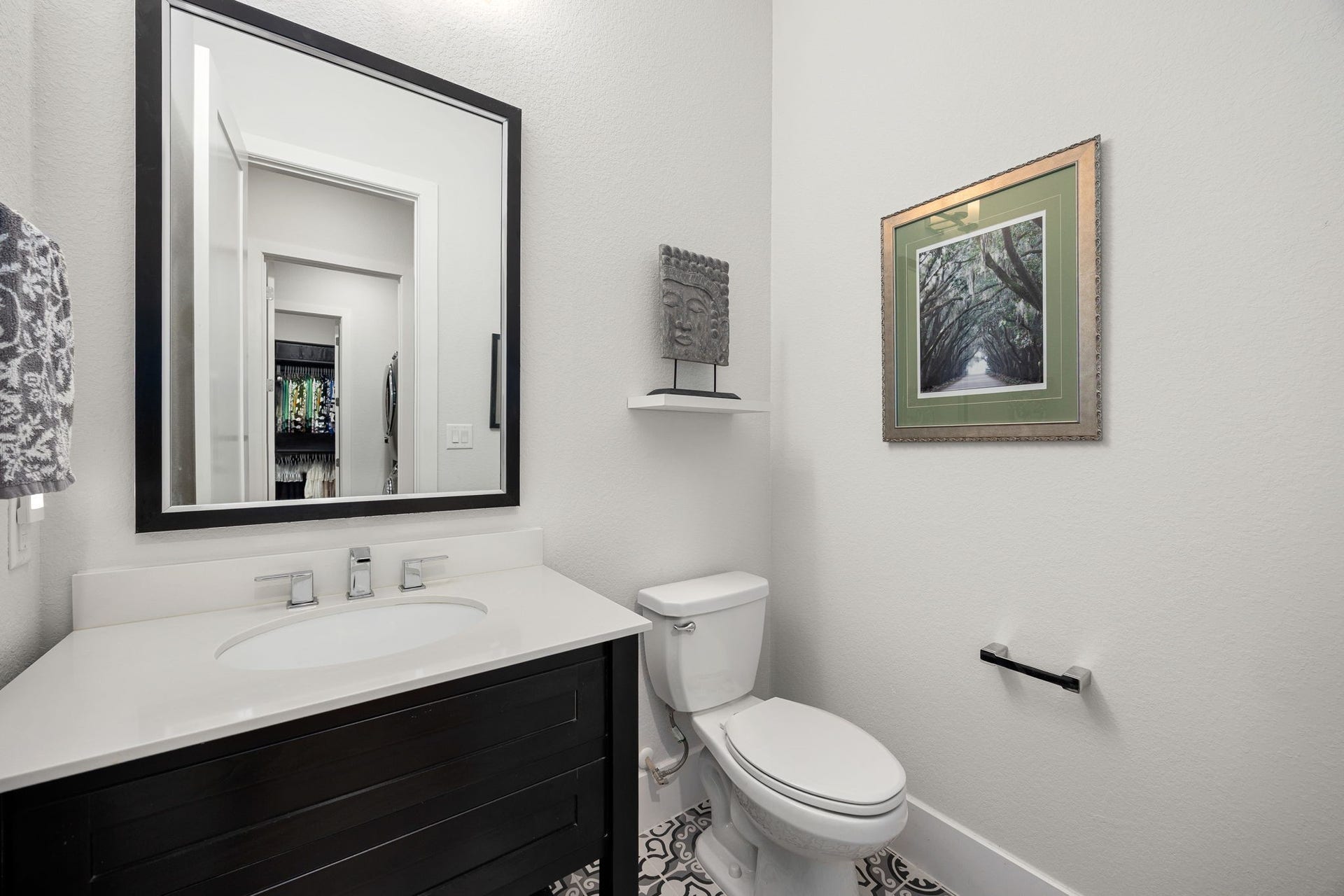 18 Gentle Branch Place, The Woodlands, TX 77375 This chic powder room makes a statement with its clean, contemporary design. Featuring a dark wood vanity topped with crisp white stone and a modern framed mirror, this elegant space is perfectly situated for guest convenience.