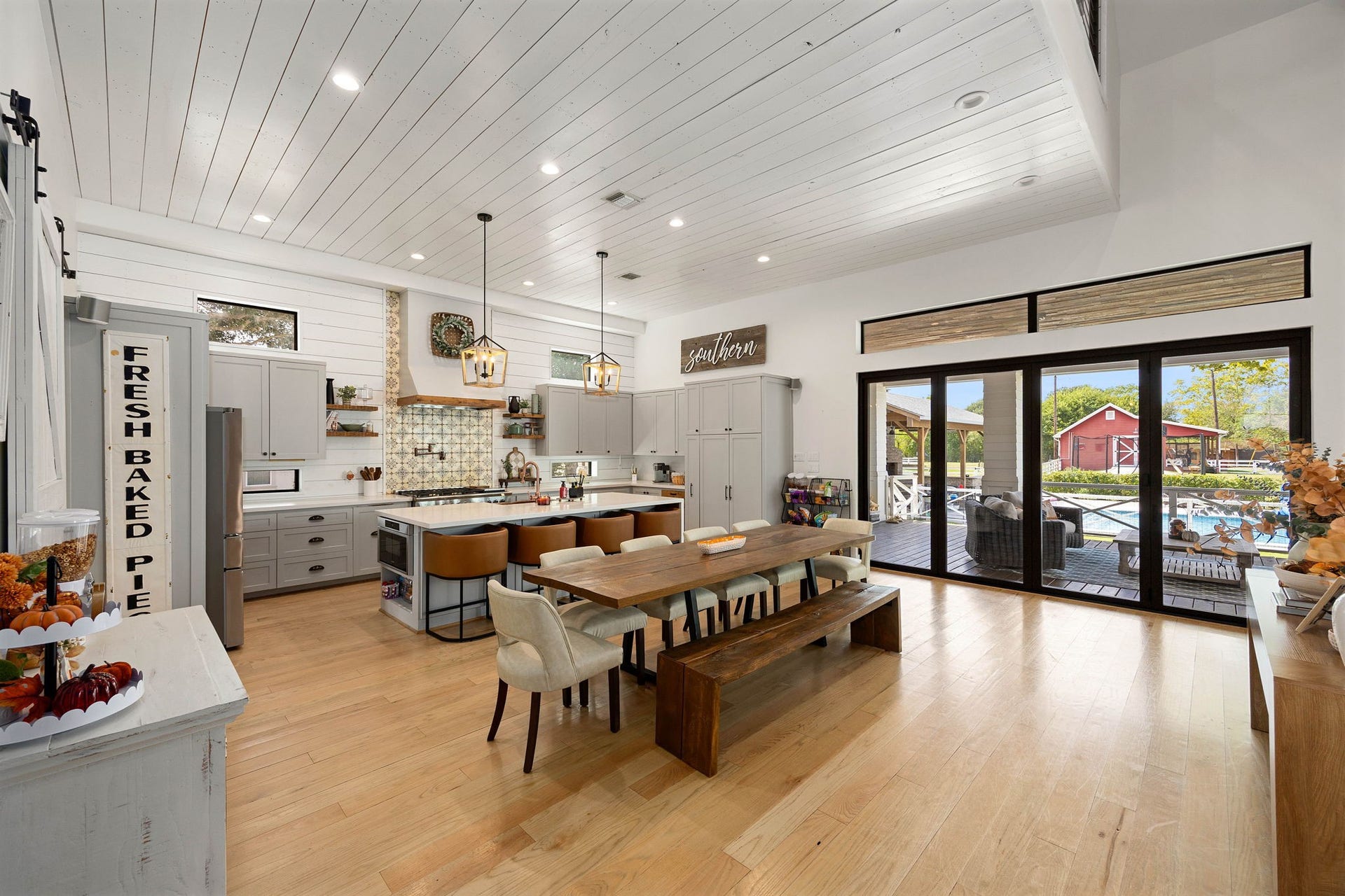 6571 Manorwood Drive, Katy, TX 77493 Designed for effortless entertaining, a large casual dining space sits adjacent to the high-end kitchen, all framed by a massive wall of multi-slide glass patio doors looking out to the pool and backyard.