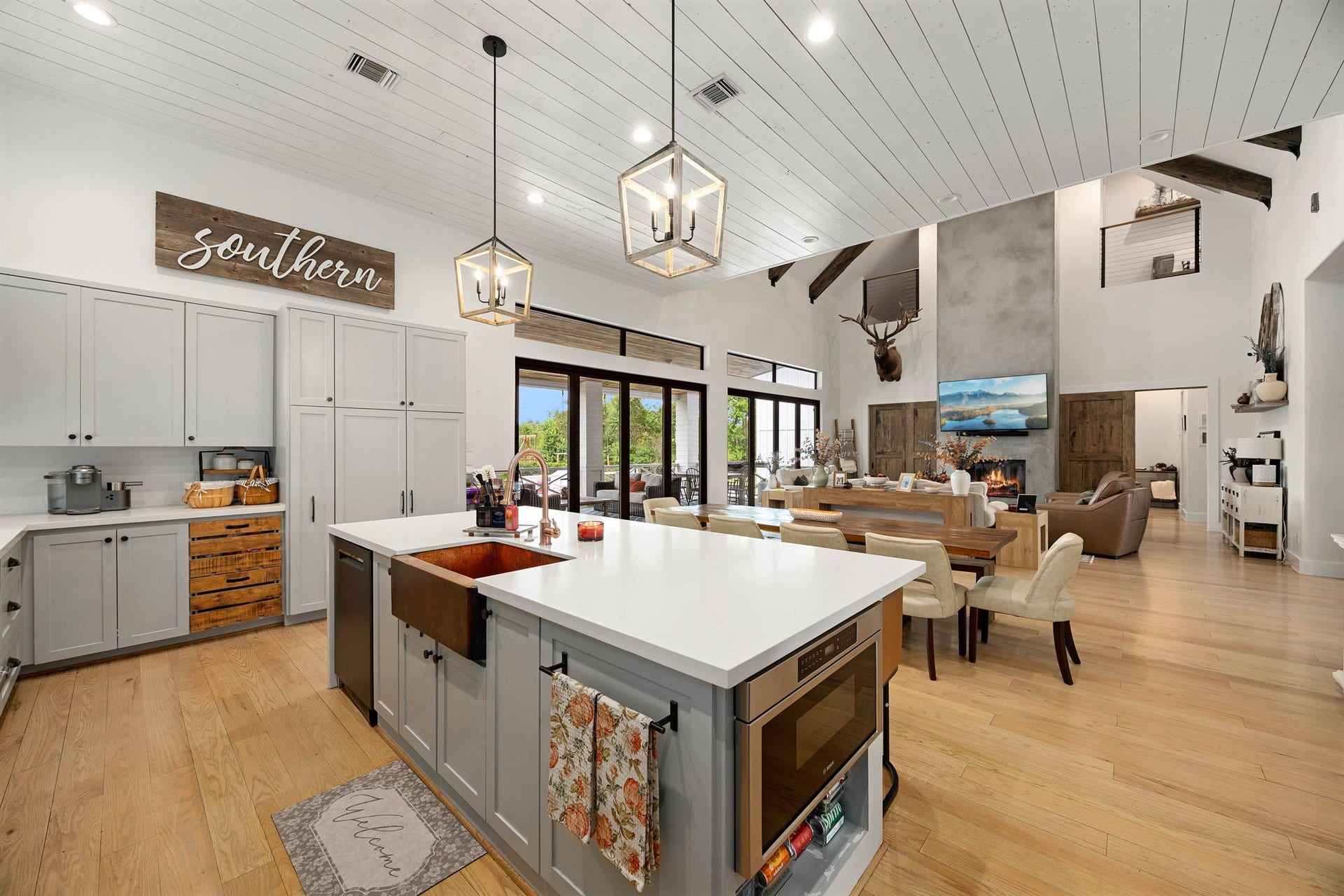 6571 Manorwood Drive, Katy, TX 77493 Standing at the massive center island features a beautiful, deep copper farmhouse apron sink with a premium bridge faucet, offering a spectacular, unobstructed view across the entire open-concept estate.