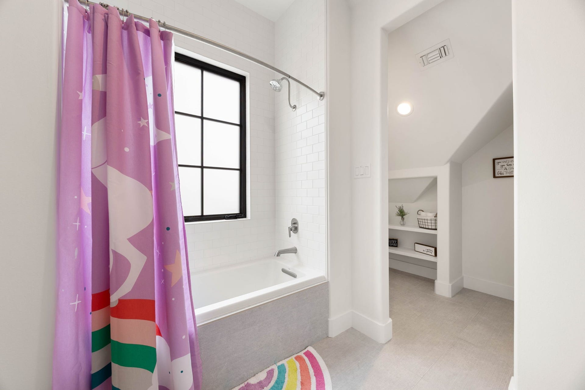 6571 Manorwood Drive, Katy, TX 77493 This bright, functional space features a deep soaking tub and shower combination wrapped in pristine subway wall tile and finished with a modern gray tile accent apron.