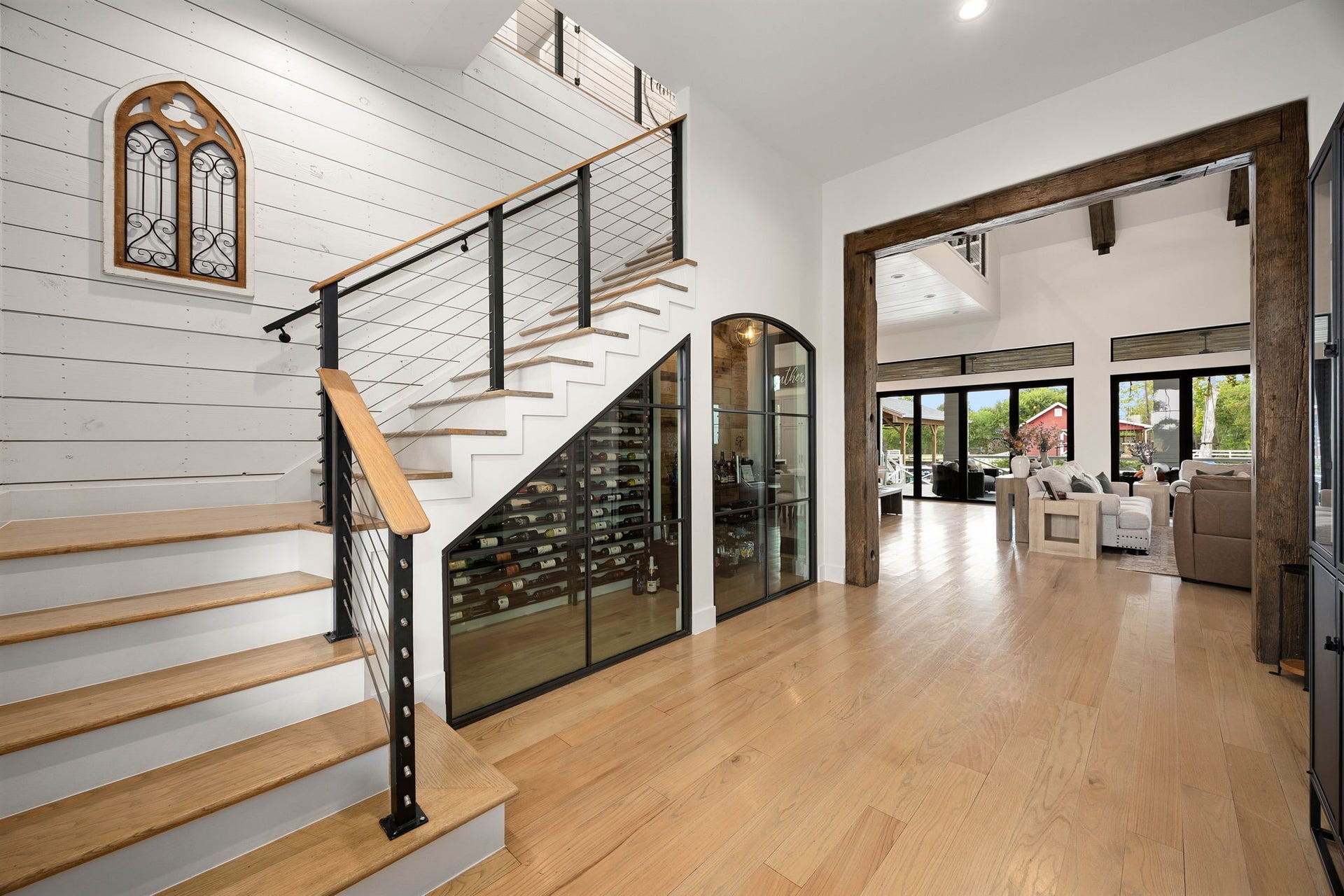 6571 Manorwood Drive, Katy, TX 77493 Luxury from the moment you step inside. Tucked masterfully beneath the main staircase is a custom, temperature-controlled glass wine cellar, featuring custom metal racking and seamless black-iron framing that turns your collection into a work of art.