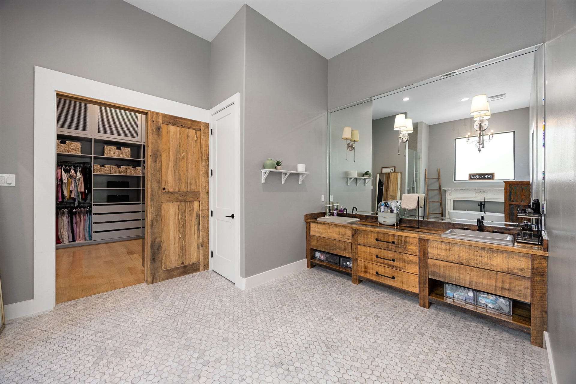 6571 Manorwood Drive, Katy, TX 77493 The primary bath features a sprawling, furniture-piece reclaimed wood vanity console complete with open shelving, soft-close drawers, a continuous floor-to-ceiling mirror panel, and premium metallic accents.