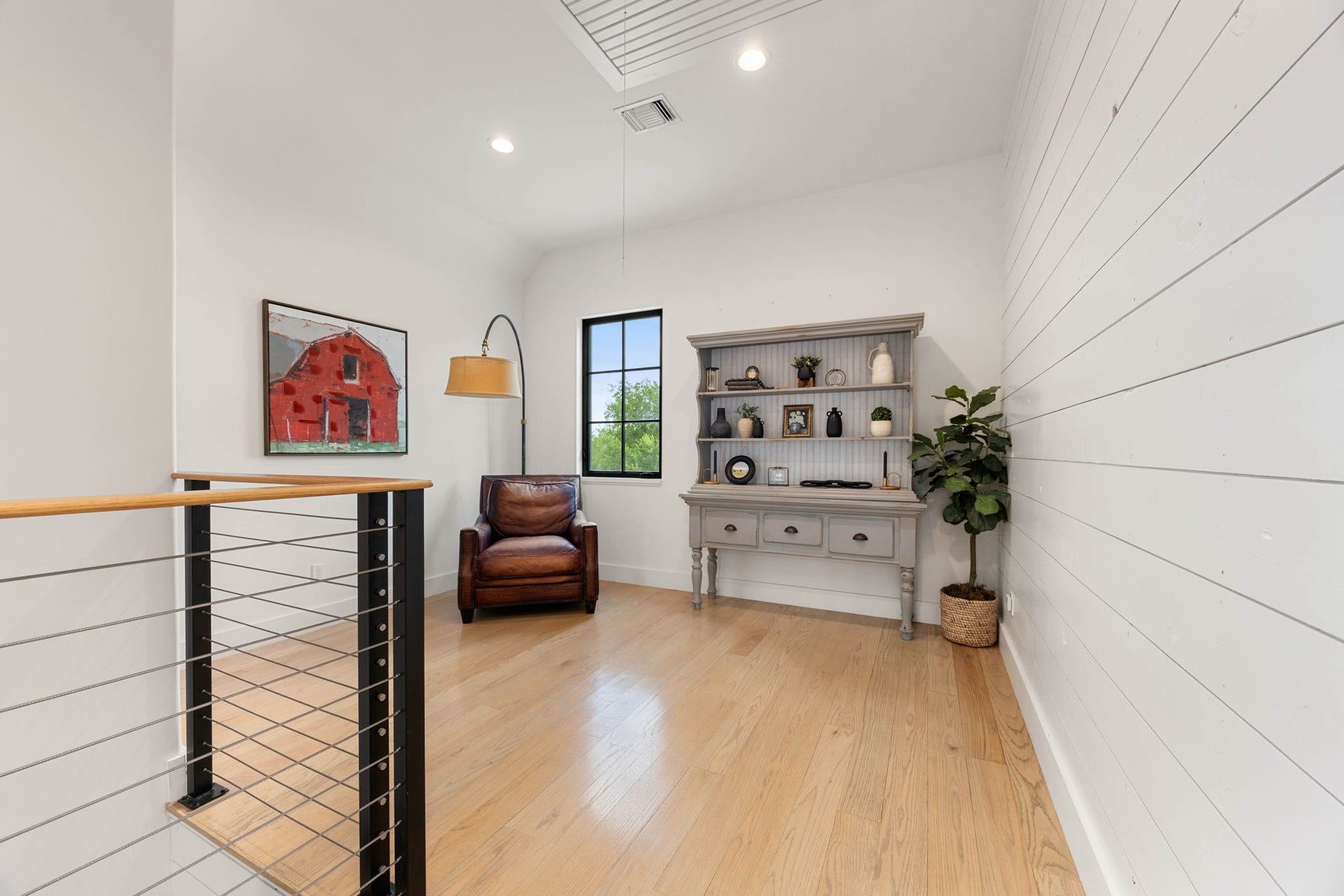 6571 Manorwood Drive, Katy, TX 77493 This bright, open flex space at the top of the stairs features a striking horizontal shiplap feature wall and beautiful wide-plank wood flooring that carries throughout the upper level.