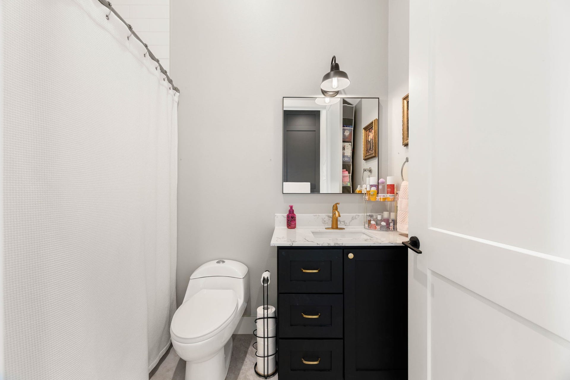 6571 Manorwood Drive, Katy, TX 77493 Serving the adjacent first-floor bedroom, this guest bath offers a complete setup including a clean, neutral tile floor, a full shower/tub combo, and high-end plumbing fixtures.