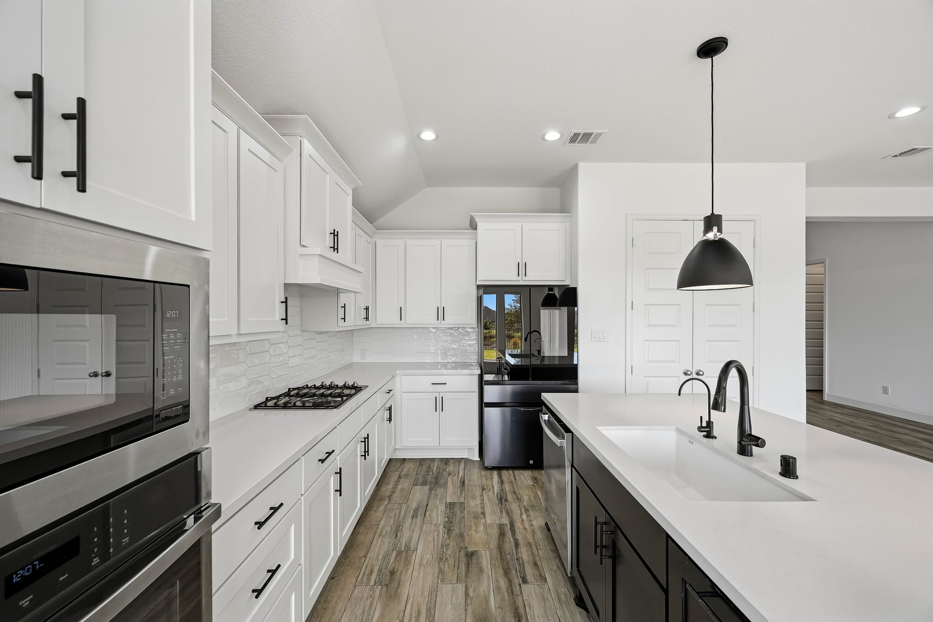 24919 Hibiscus Garden Way, Katy, TX 77493 This functional workspace maximizes prep surface and storage capacity. Integrated task lighting and enduring wide-plank floors create a seamless, fluid transition into the adjacent living quarters.
