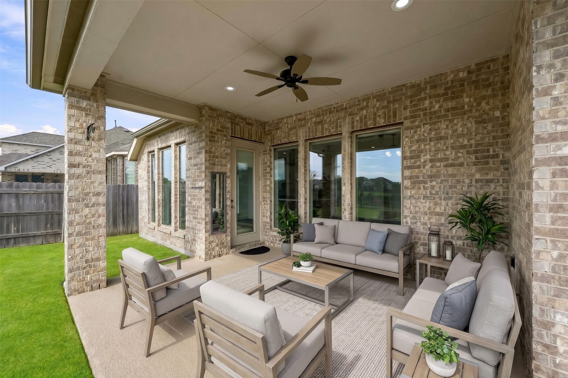 24919 Hibiscus Garden Way, Katy, TX 77493 Virtually Staged: A sheltered outdoor retreat, this expansive covered patio offers seamless flow into the backyard. The solid brick structure, durable slab flooring, integrated overhead lighting, and cooling fan combine to create a versatile footprint suited for gathering in any season.