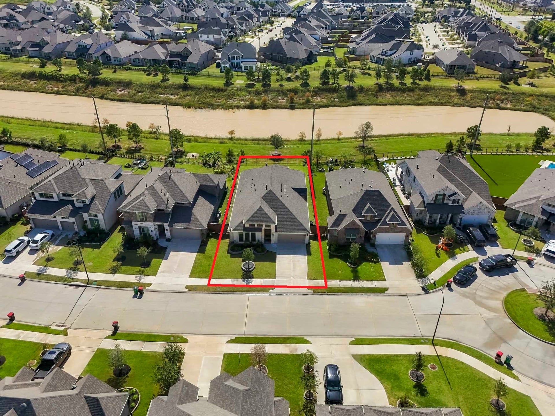 24919 Hibiscus Garden Way, Katy, TX 77493 Highlighting the level grass areas, perimeter fencing, and the front entry off a suburban street, this perspective offers a clear sense of the property's proportions, setback, and peaceful scenic backdrop.