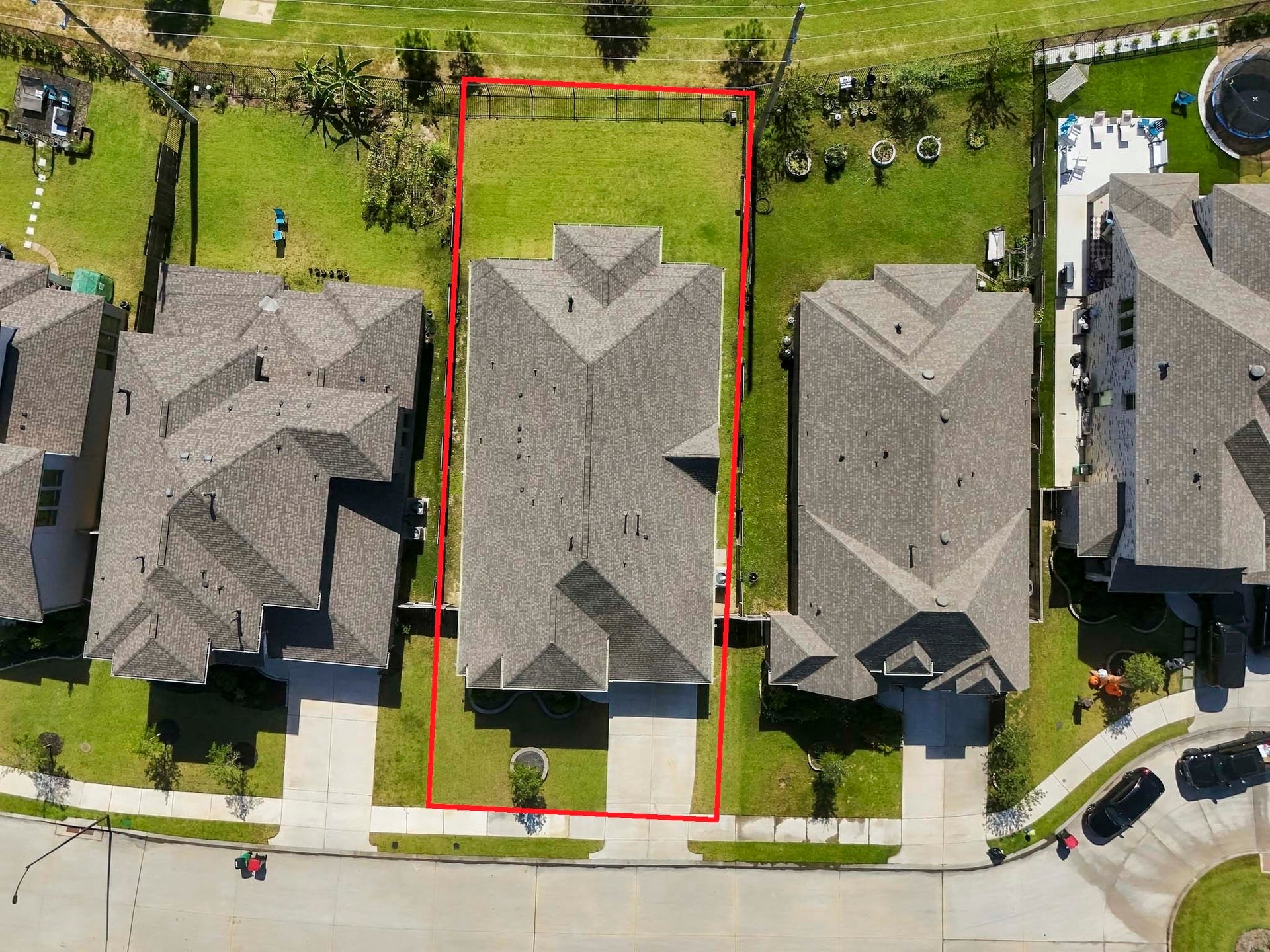 24919 Hibiscus Garden Way, Katy, TX 77493 An aerial perspective of the property reveals its spacious and level layout within a planned residential neighborhood. Features include a sizeable, fenced-in backyard, a deep covered back patio, and a driveway at the front.