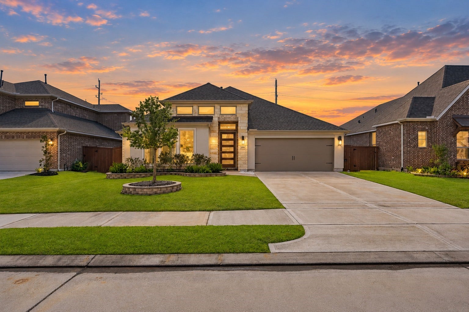 24919 Hibiscus Garden Way, Katy, TX 77493 Step into refined curb appeal featuring an expansive architectural footprint, multi-pitched rooflines, and natural stone accents. Prominent exterior illumination and upper-level accent windows highlight the home's grand proportions and airy elevation.