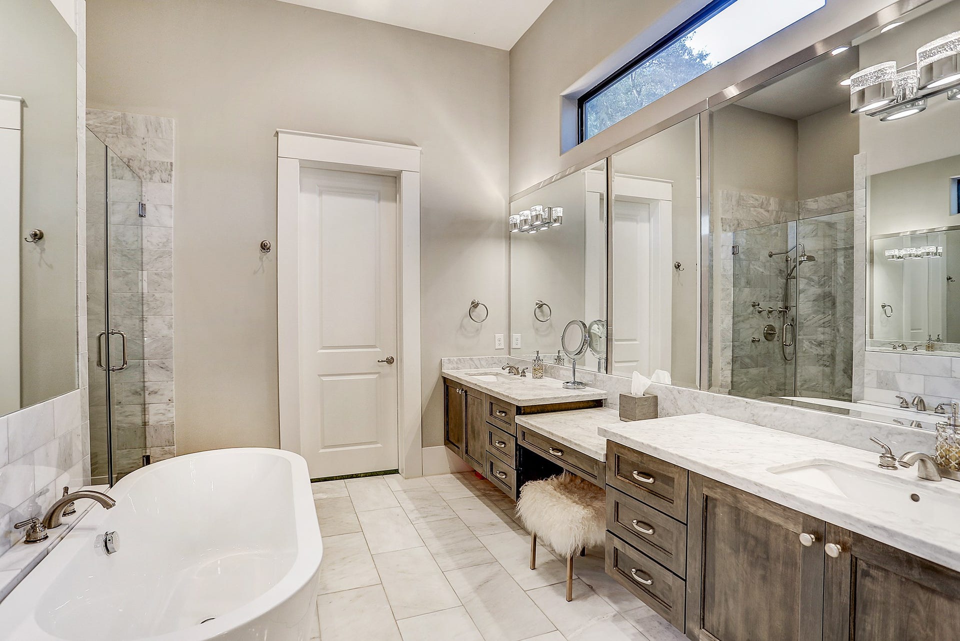11x12 master bath has marble tile floor, standing shower with white snow marble surround, two sink areas with Carrara marble counters, transom window and custom lighting.