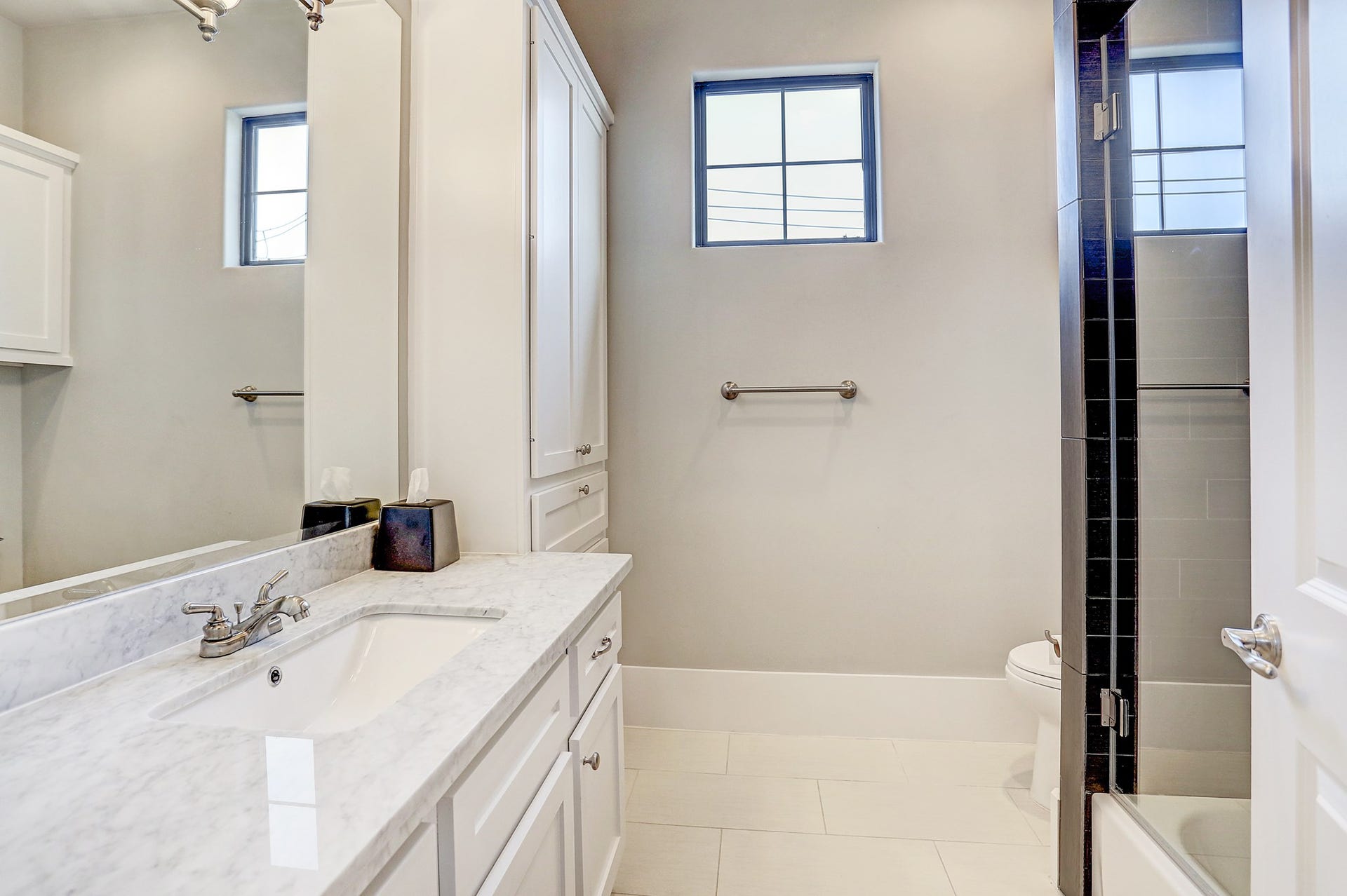 4th full bath adjacent to the 4th bedroom upstairs also services the gameroom. It has tile floor, tub/shower combo with subway tile surround, Carrara marble counter, and custom lighting.