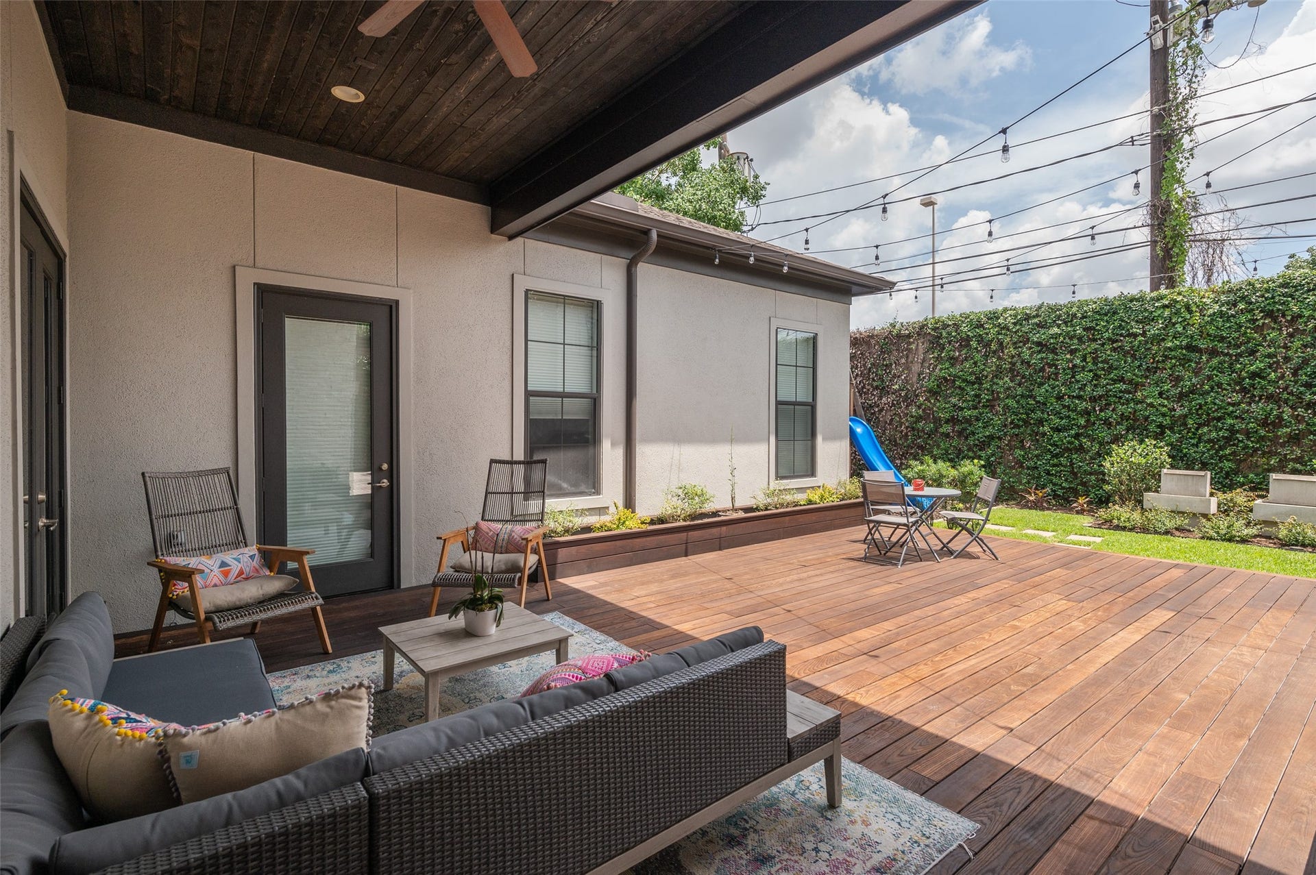 Expansive covered patio with stained hardwood ceiling, ceiling fan and recessed lighting.