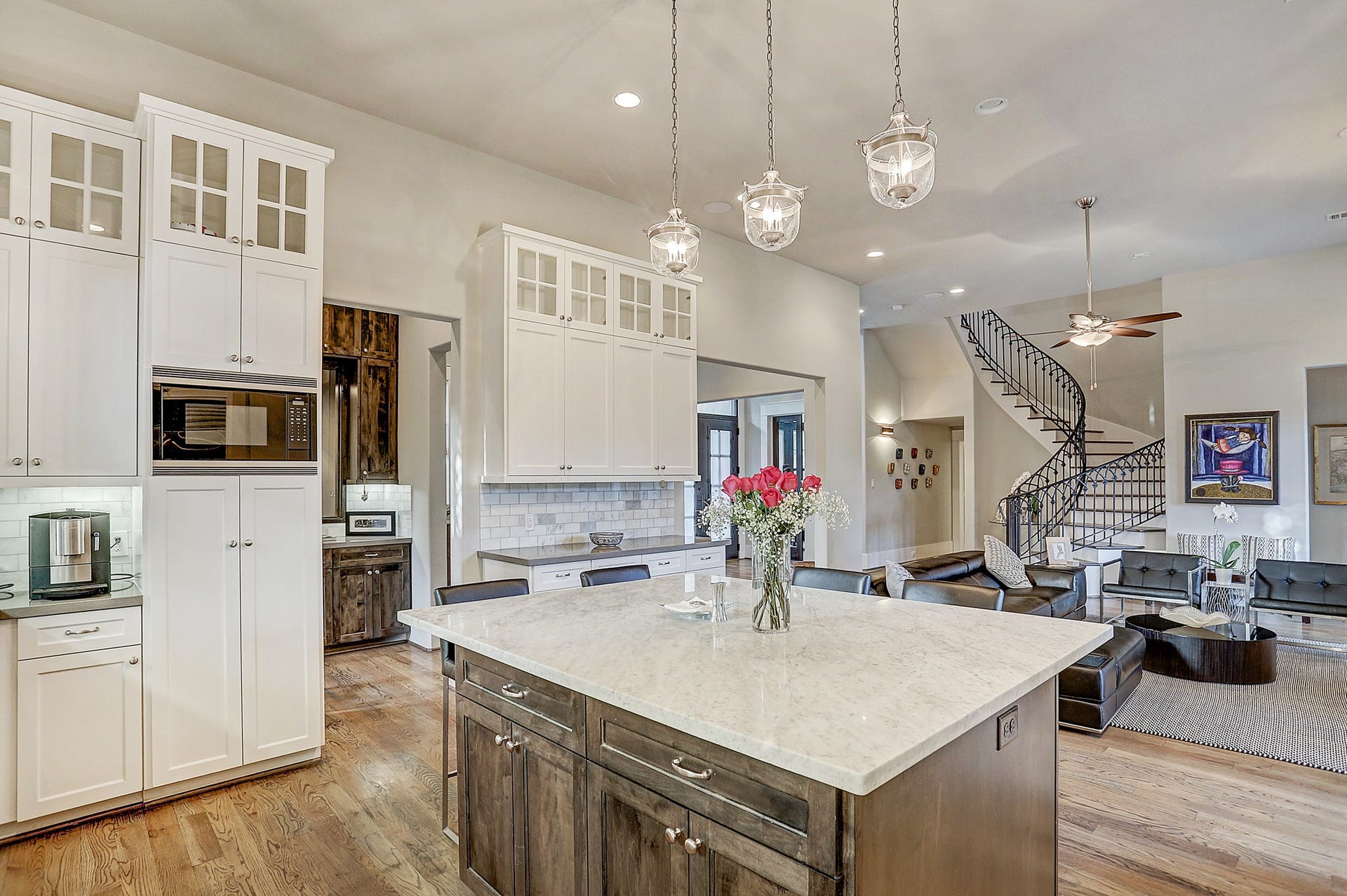 Kitchen has a large Carrara marble island with pendant lighting and 5 stool seating.