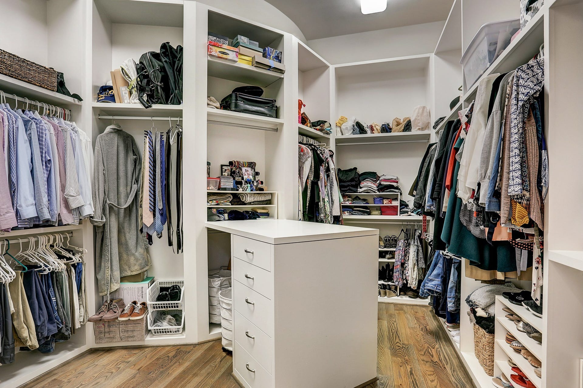 Enormous master closet has custom built ins including packing table.