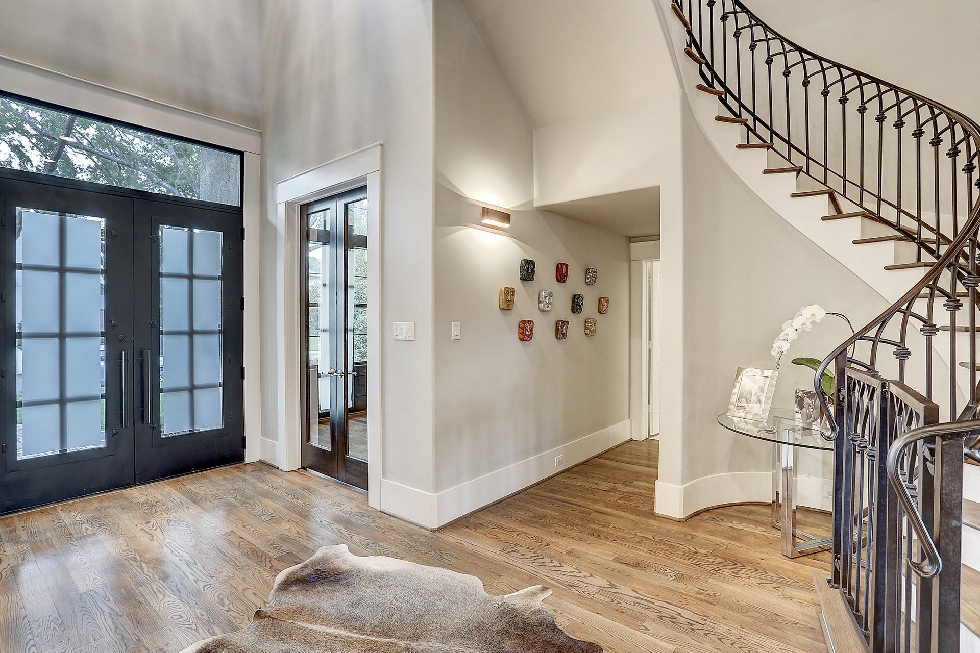 Double glass doors lead to the study, and the powder bath is down the hall. The wrought iron stair railing has built in safety gates at the bottom and top of the stairs (which can be removed if desired).