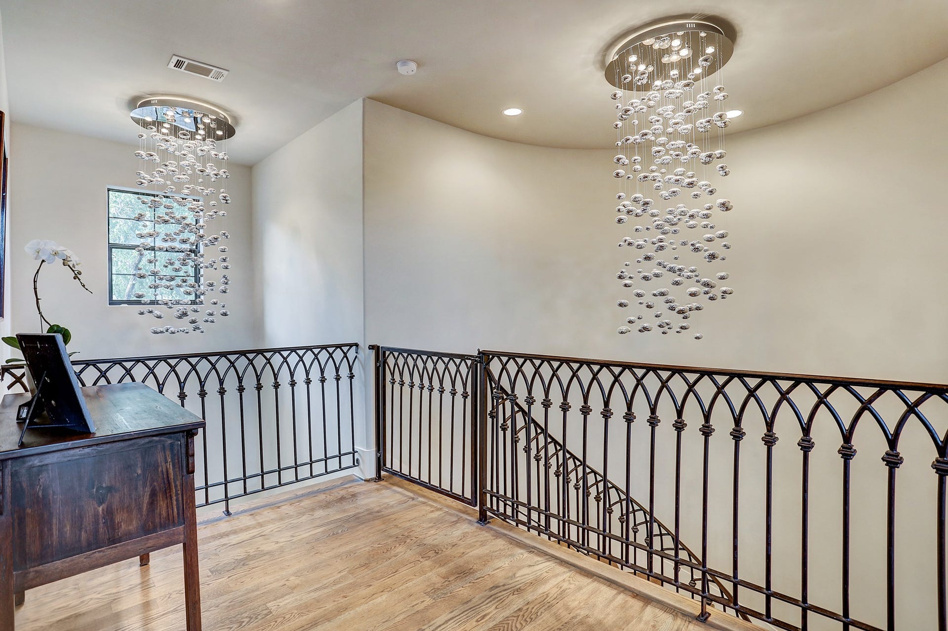 Landing area on the second floor provides room to display furniture or art.  The custom chandeliers add modern stylish flair.