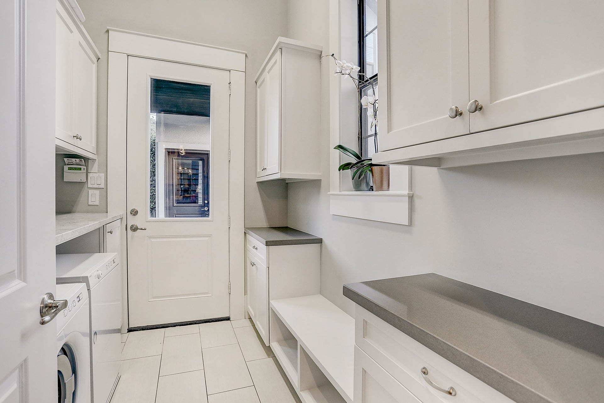 Utility room / mud room has tile floor and ample folding/storage space.