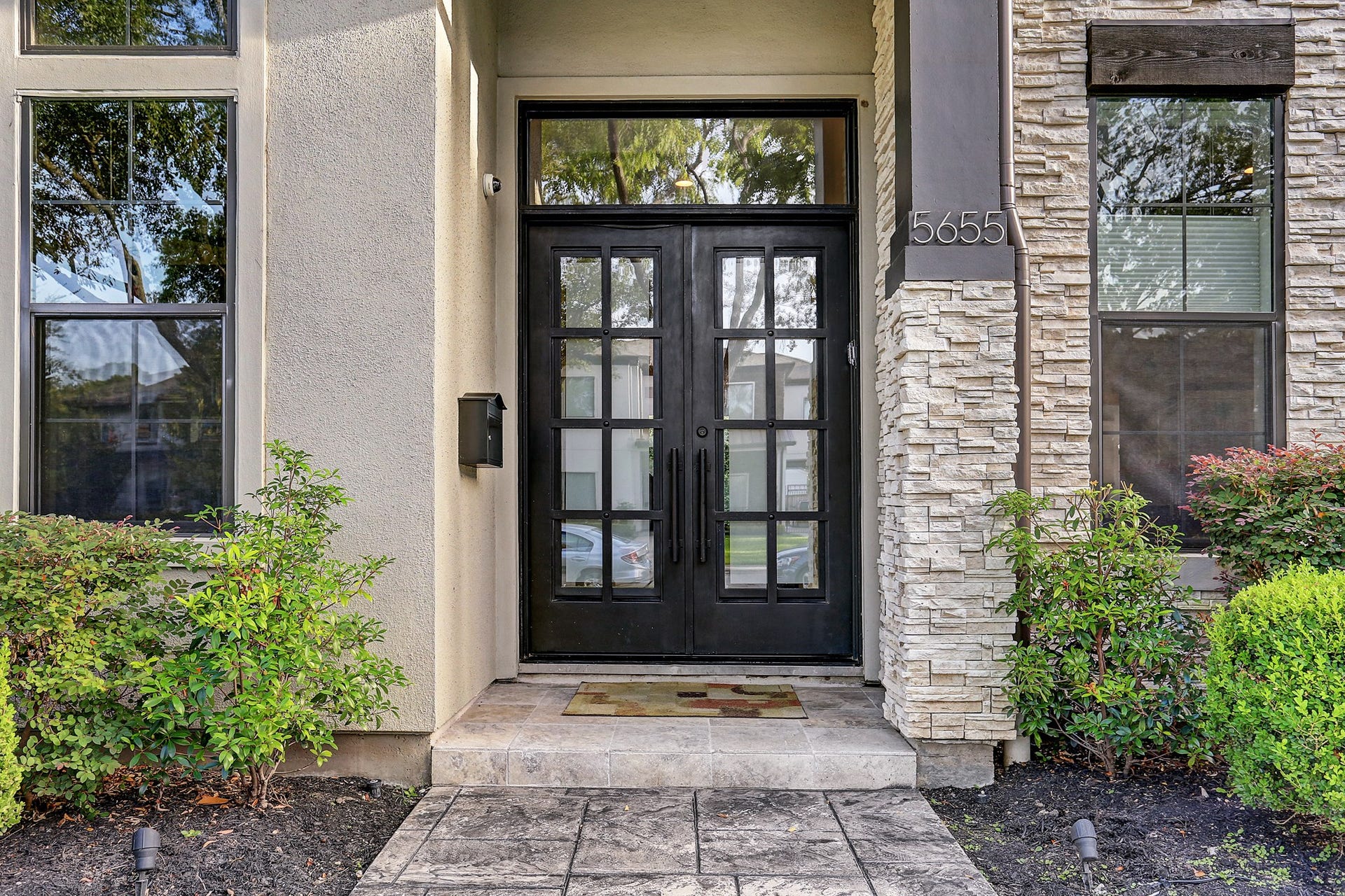 Covered front entry features a custom Cantera double door and transom window.