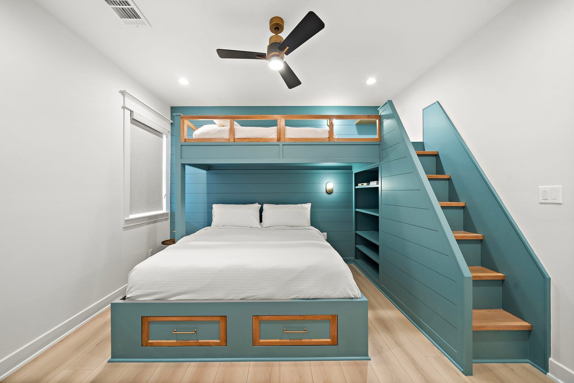 1825 Avenue N Street, Galveston, TX 77550 Secondary bedroom with built-in bunk beds, adjustable shelving, lighting and stairs to the top bunk. Kingsized on bottom and twin on top. Two drawers located at base of king sized bed.