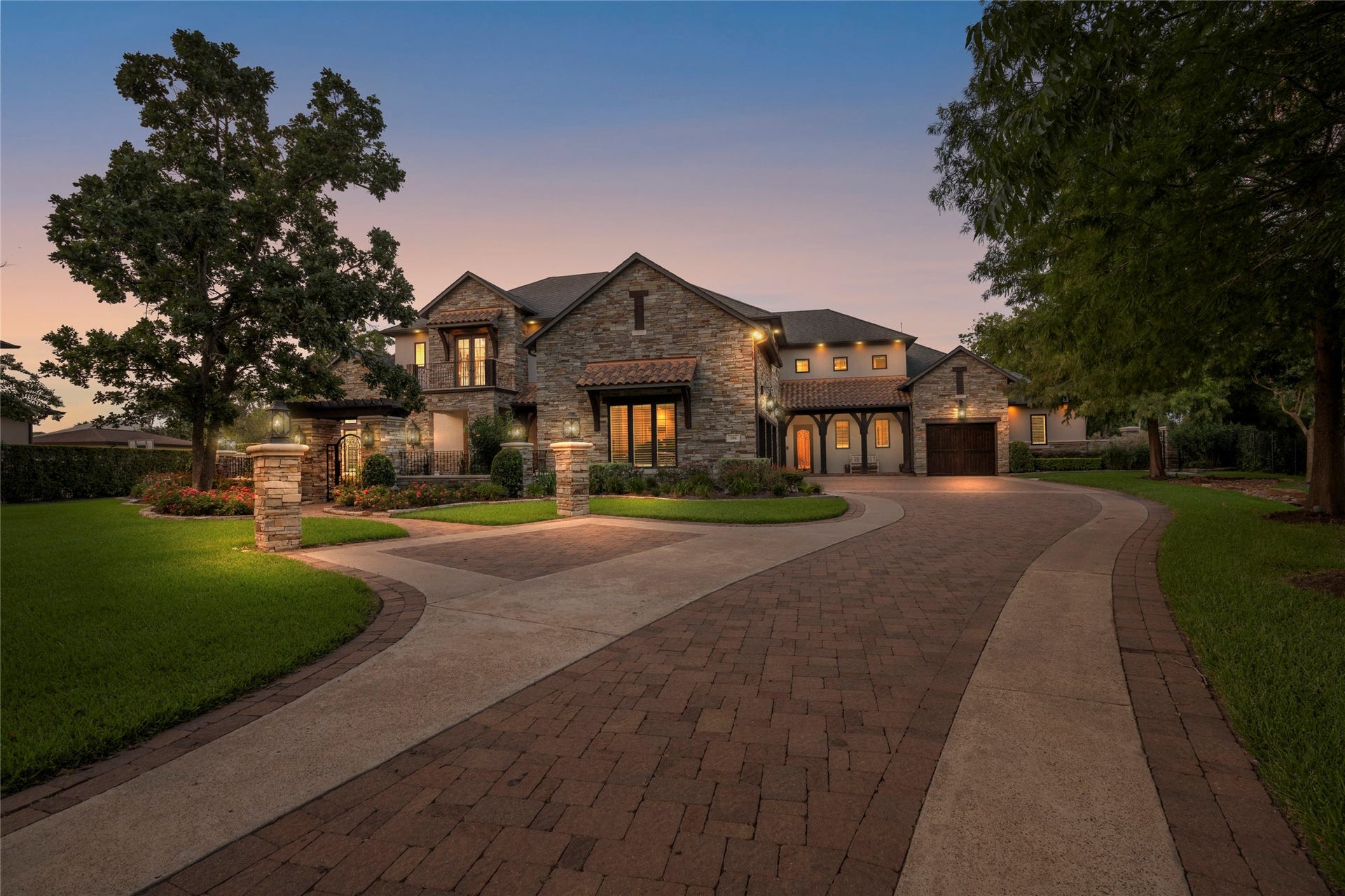 106 Big Trail Court, Missouri City, TX 77459 Welcome to 106 Big Trail Court, with stone and stucco elevation, custom lantern lighting, and a paver motor court framed by mature trees.