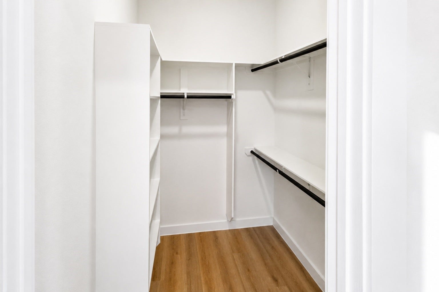 Well appointed walk in closet offers custom built shelving, multiple hanging sections, and generous storage for clothing, shoes, and accessories. Thoughtful organization maximizes every inch while keeping the primary suite clean, functional, and beautifully uncluttered