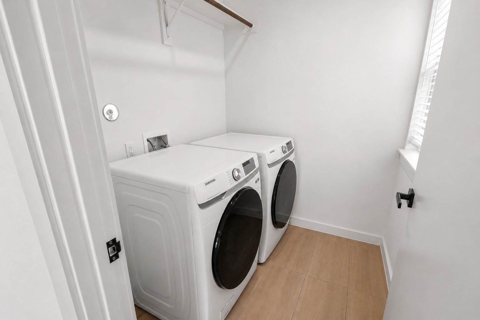 Dedicated utility room includes full size washer and dryer connections with additional overhead storage and natural light. Positioned on the first floor for convenience, the space keeps everyday chores tucked away while remaining easily accessible.