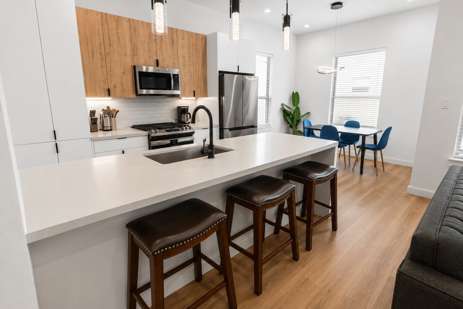Oversized waterfall island anchors the kitchen while providing generous prep space, casual seating, and a natural gathering place for family and friends. Quartz countertops, stainless steel appliances, full height cabinetry, designer pendant lighting, and a dedicated dining area combine to create a kitchen that is as functional as it is beautiful.