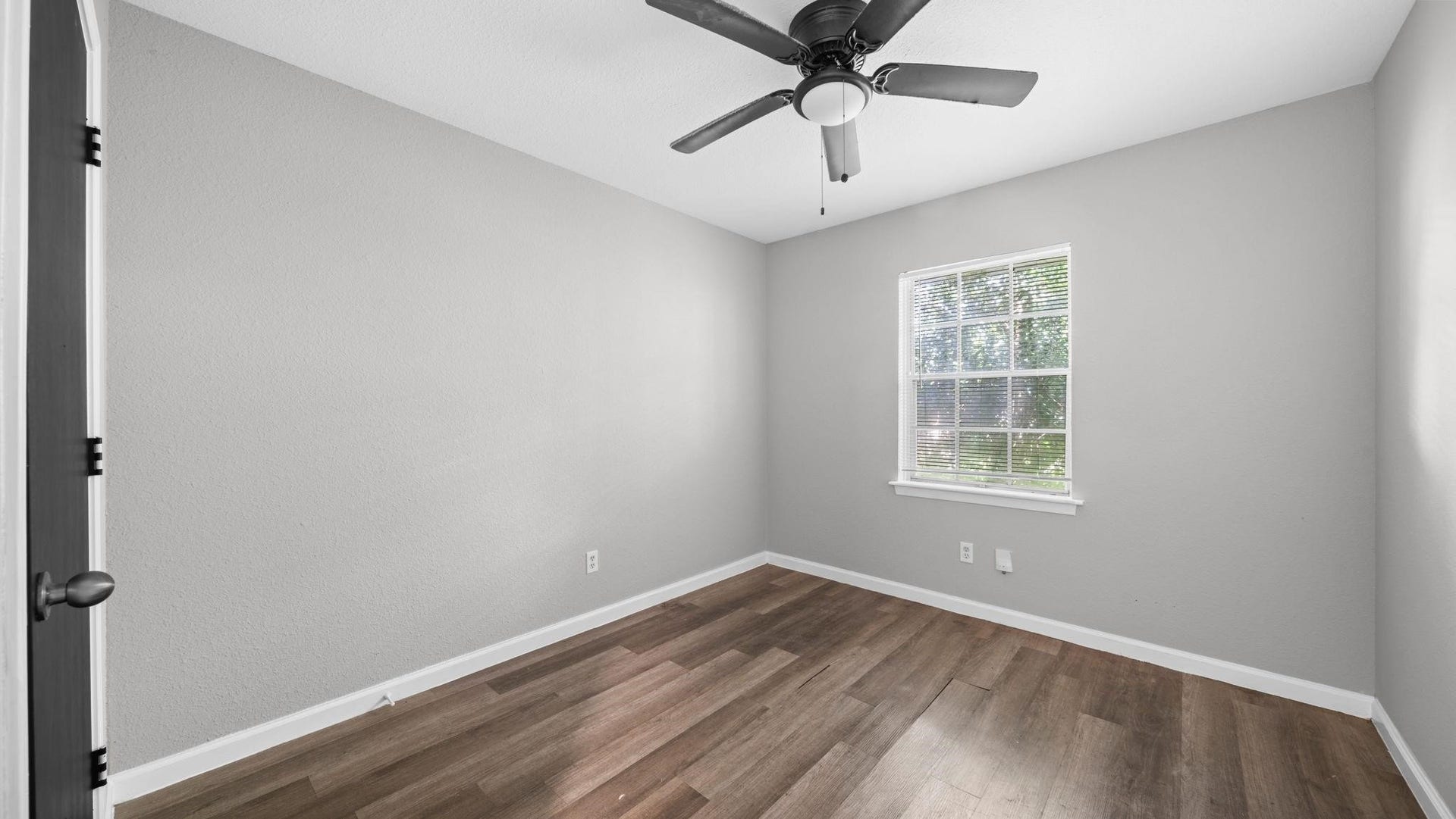 5242 Greylog Drive, Houston, TX 77048 The fourth bedroom offers an appealing combination of comfort and versatility, featuring luxury vinyl flooring, a window with blinds, a ceiling fan with integrated lighting, and a spacious walk-in closet. This well-appointed space easily accommodates guests, a private home office, or a creative studio.