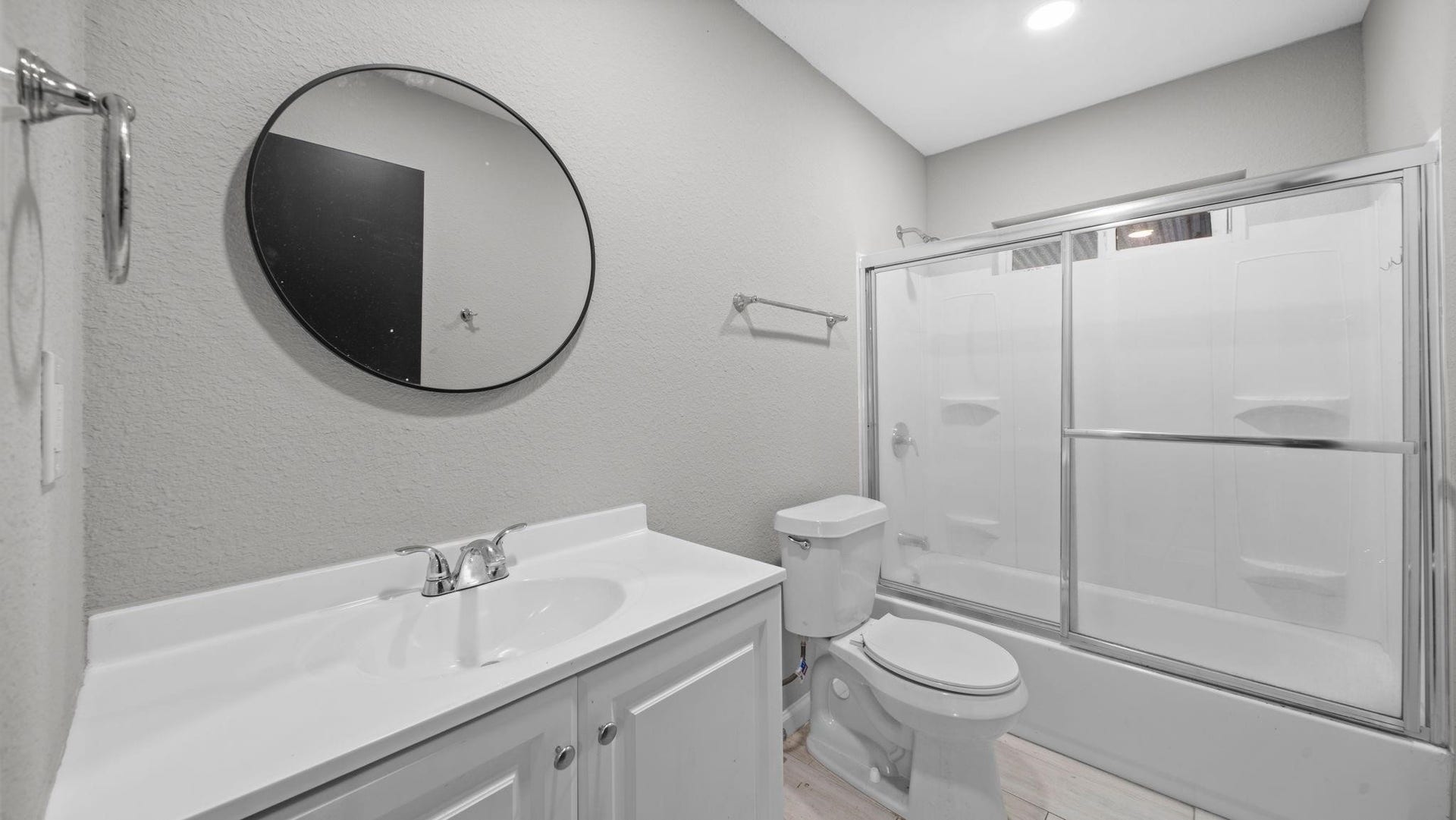 5242 Greylog Drive, Houston, TX 77048 The secondary bath features elegant 12 x 24-inch tile flooring, a cultured marble vanity, and recessed lighting for a clean, contemporary aesthetic. A tub/shower combination with a sliding glass door is complemented by a window above the shower, inviting natural light into the space.