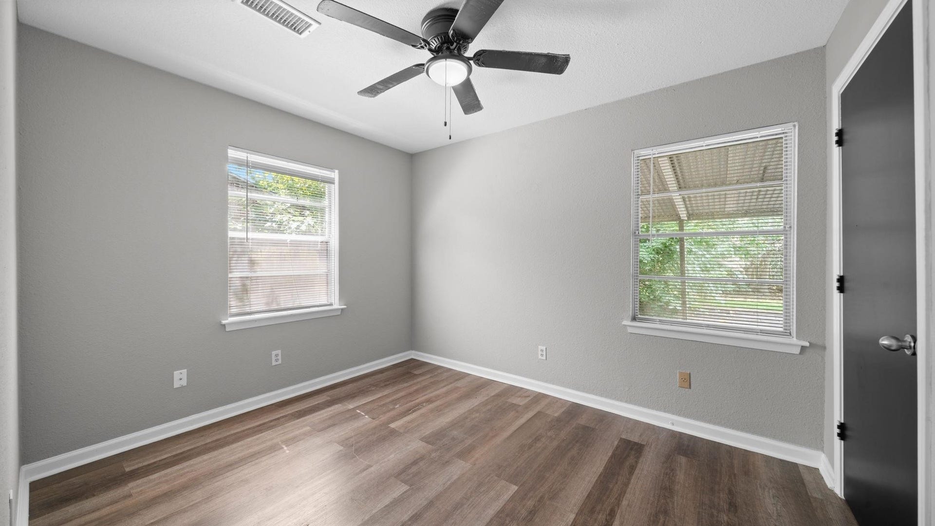 5242 Greylog Drive, Houston, TX 77048 The third bedroom offers a bright, welcoming atmosphere, with two windows featuring blinds that invite natural light into the space. A ceiling fan with integrated lighting adds comfort, while a spacious walk-in closet provides ample storage and organization.