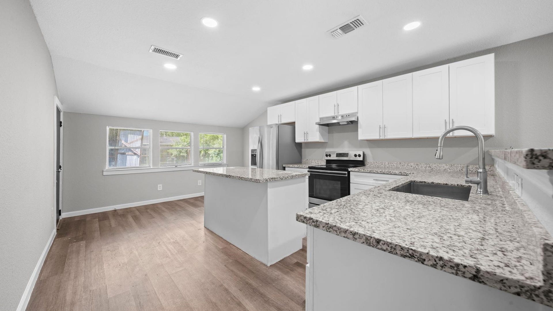 5242 Greylog Drive, Houston, TX 77048 Elegant granite countertops complement an expansive 10-foot breakfast bar, offering generous workspace for culinary preparation, casual dining, and a welcoming place to gather.