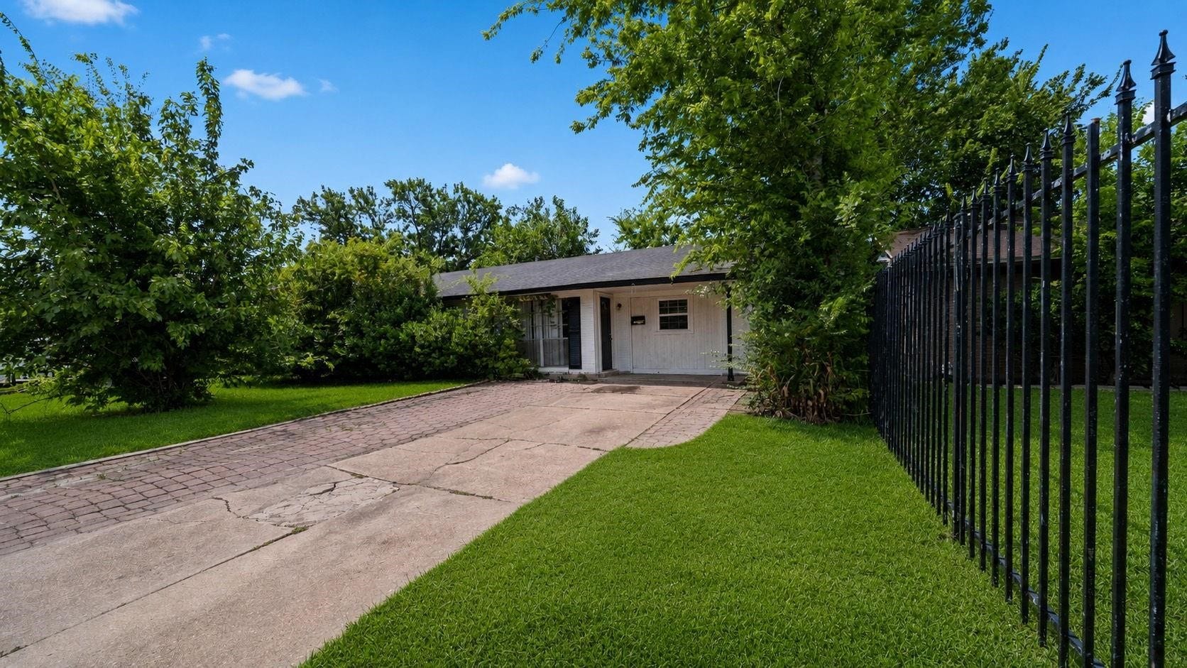 5242 Greylog Drive, Houston, TX 77048 Mature shade trees and a spacious paved driveway create inviting curb appeal with plenty of room for guests.