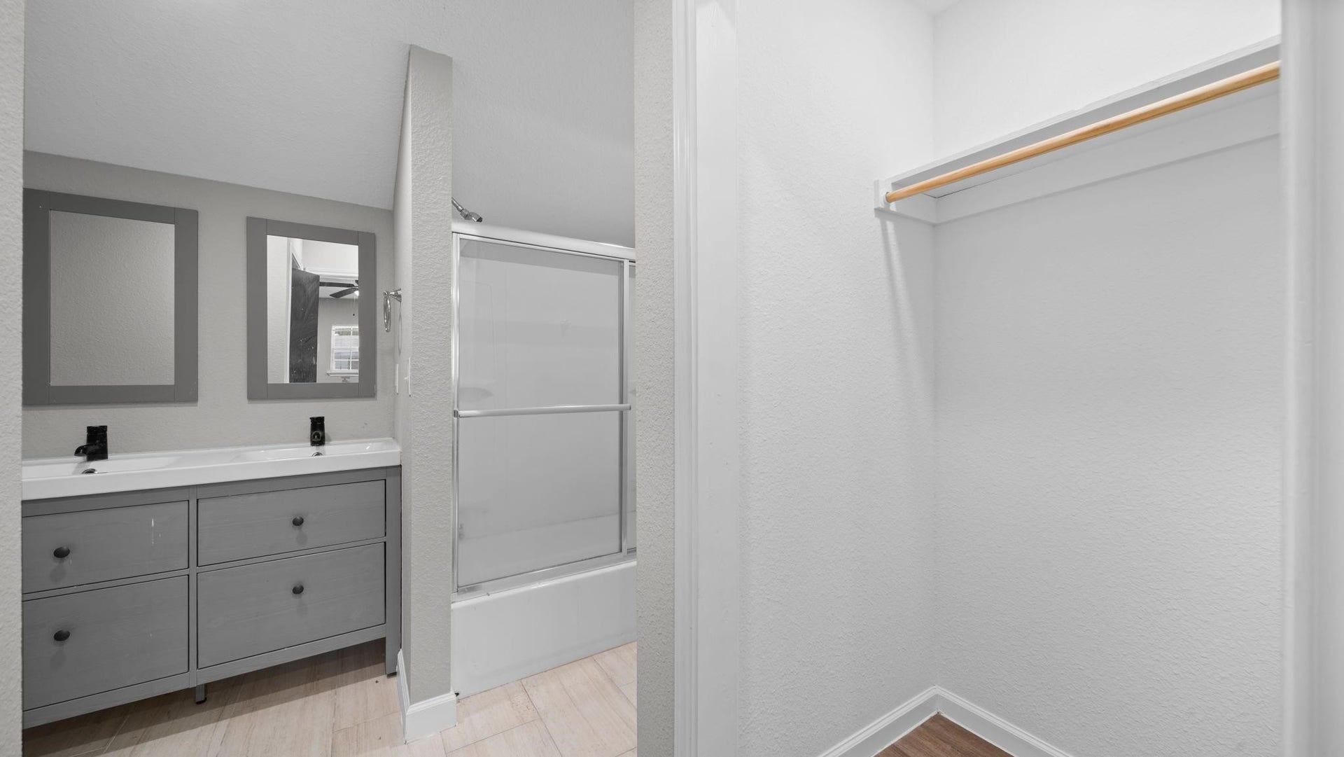 5242 Greylog Drive, Houston, TX 77048 The en-suite primary bath showcases an expansive dual-sink vanity complemented by sleek contemporary cabinetry, creating an elegant balance of modern sophistication and everyday comfort.