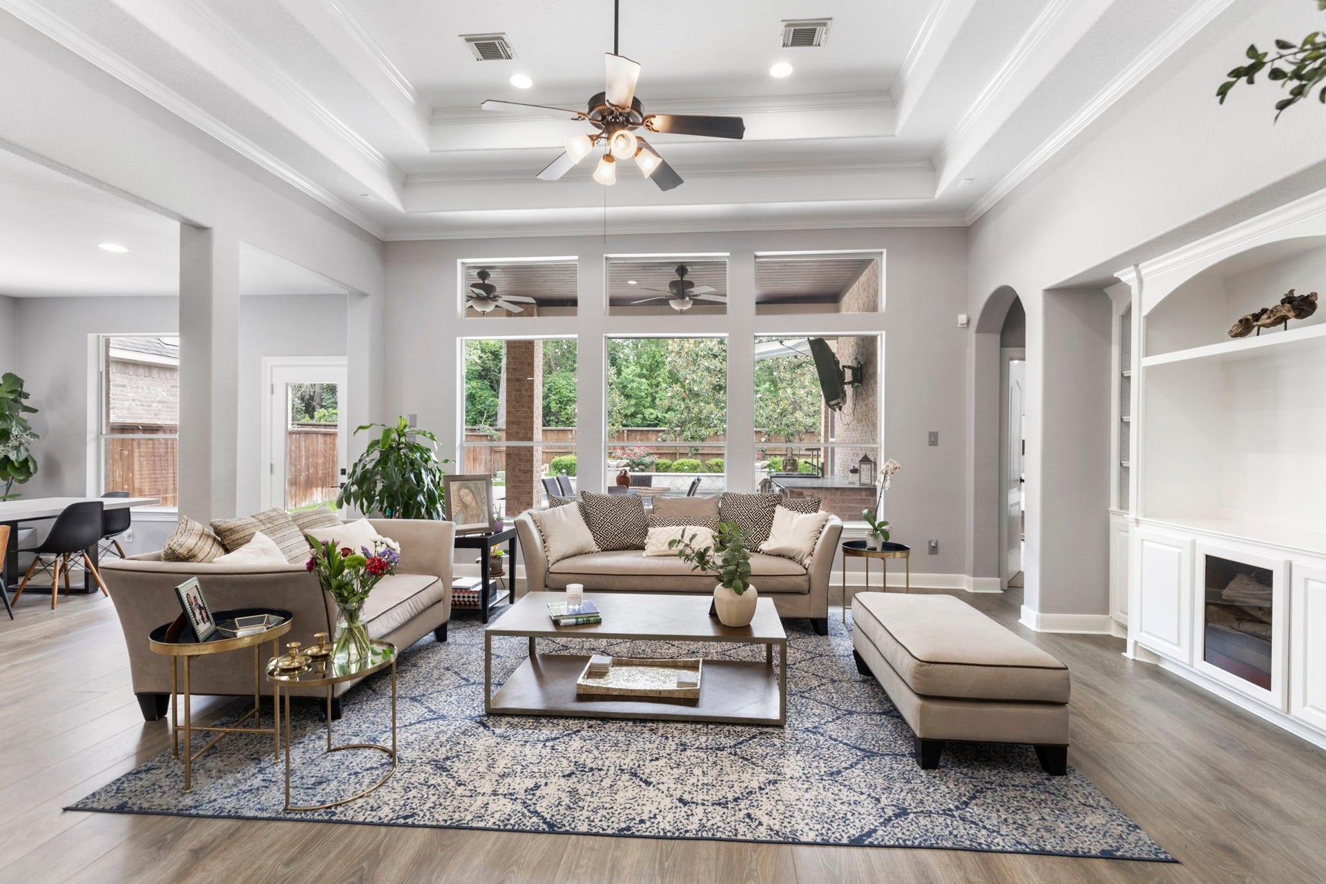 130 S Arrow Canyon Circle, The Woodlands, TX 77389 This spacious living room features a modern, open layout with trey ceilings and large windows that let in plenty of natural light. Perfect for comfortable living and entertaining.