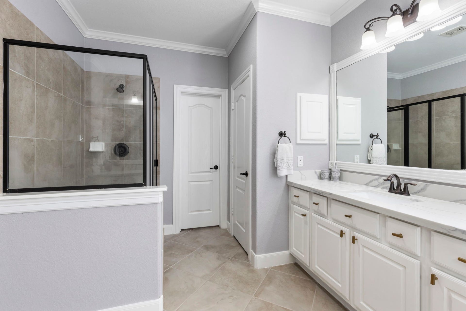 130 S Arrow Canyon Circle, The Woodlands, TX 77389 This bathroom features a spacious walk-in shower with a glass door and ample storage.