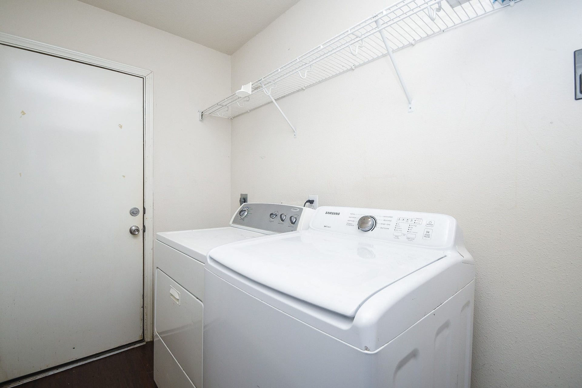 10222 Antelope Alley, Missouri City, TX 77459 Convenient laundry room equipped with a washer and dryer, featuring a shelf for storage and a door for easy access.