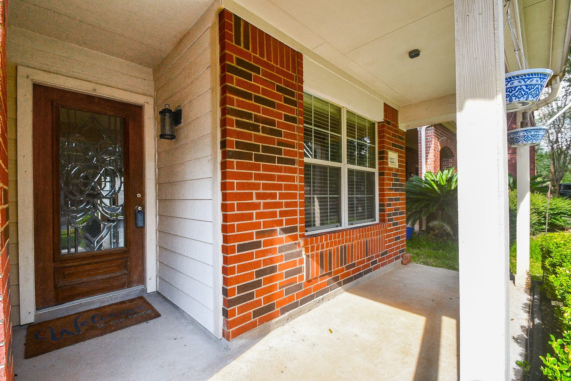 10222 Antelope Alley, Missouri City, TX 77459 Charming brick front porch with an elegant glass-paneled door and cozy seating area, perfect for relaxing outdoors.