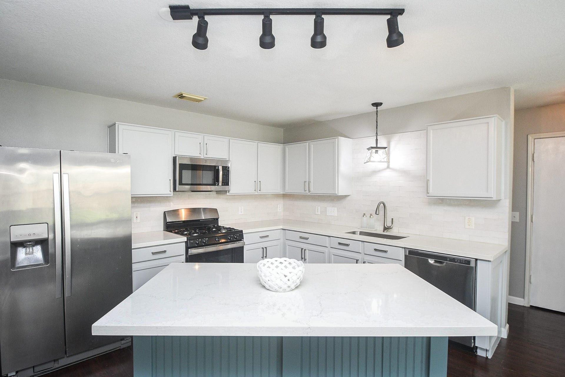 10222 Antelope Alley, Missouri City, TX 77459 Modern kitchen featuring sleek stainless steel appliances, white cabinetry, and a spacious island with elegant lighting.