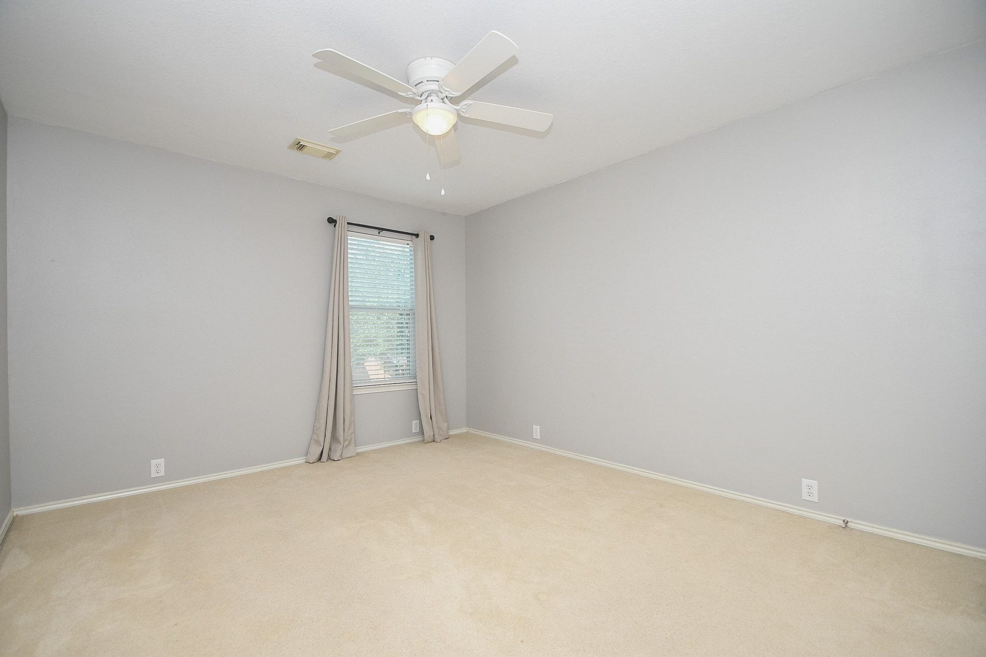 10222 Antelope Alley, Missouri City, TX 77459 Spacious room with neutral walls, plush carpeting, and a ceiling fan, featuring a large window for ample natural light.