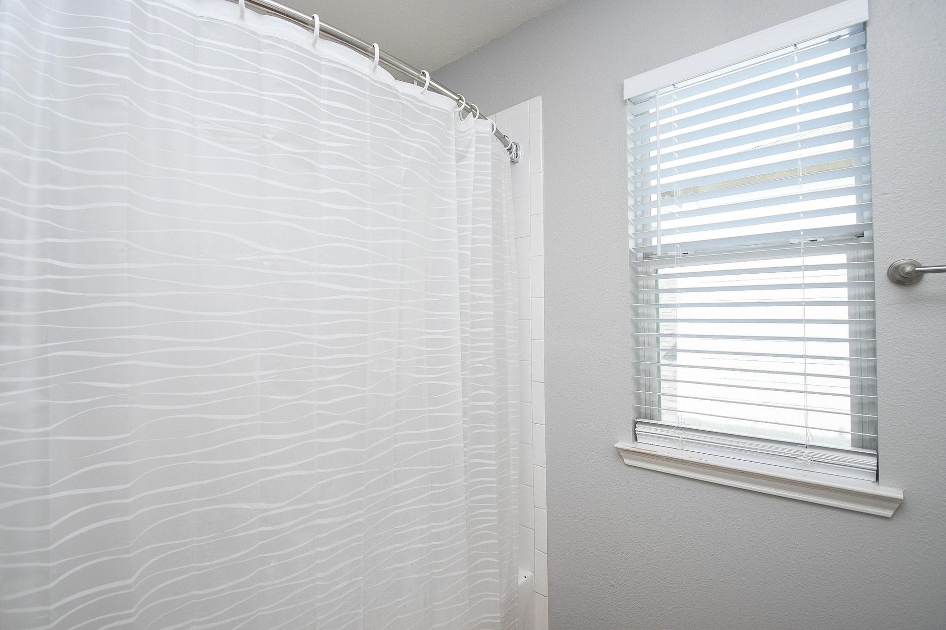 10222 Antelope Alley, Missouri City, TX 77459 Bright bathroom featuring a modern shower with a textured curtain and a window for natural light.