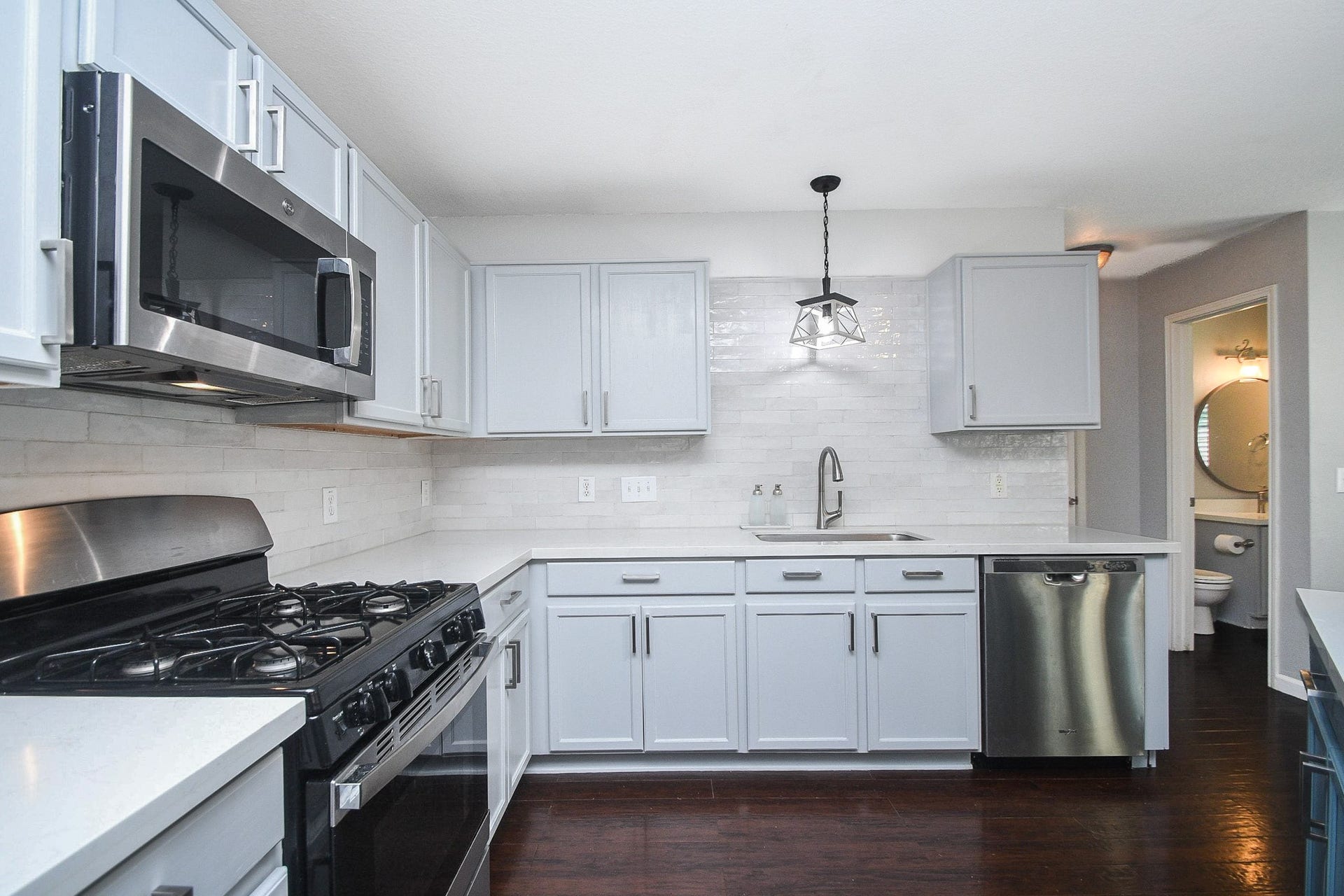 10222 Antelope Alley, Missouri City, TX 77459 Sleek kitchen with modern stainless steel appliances, elegant white cabinetry, and a stylish tile backsplash.