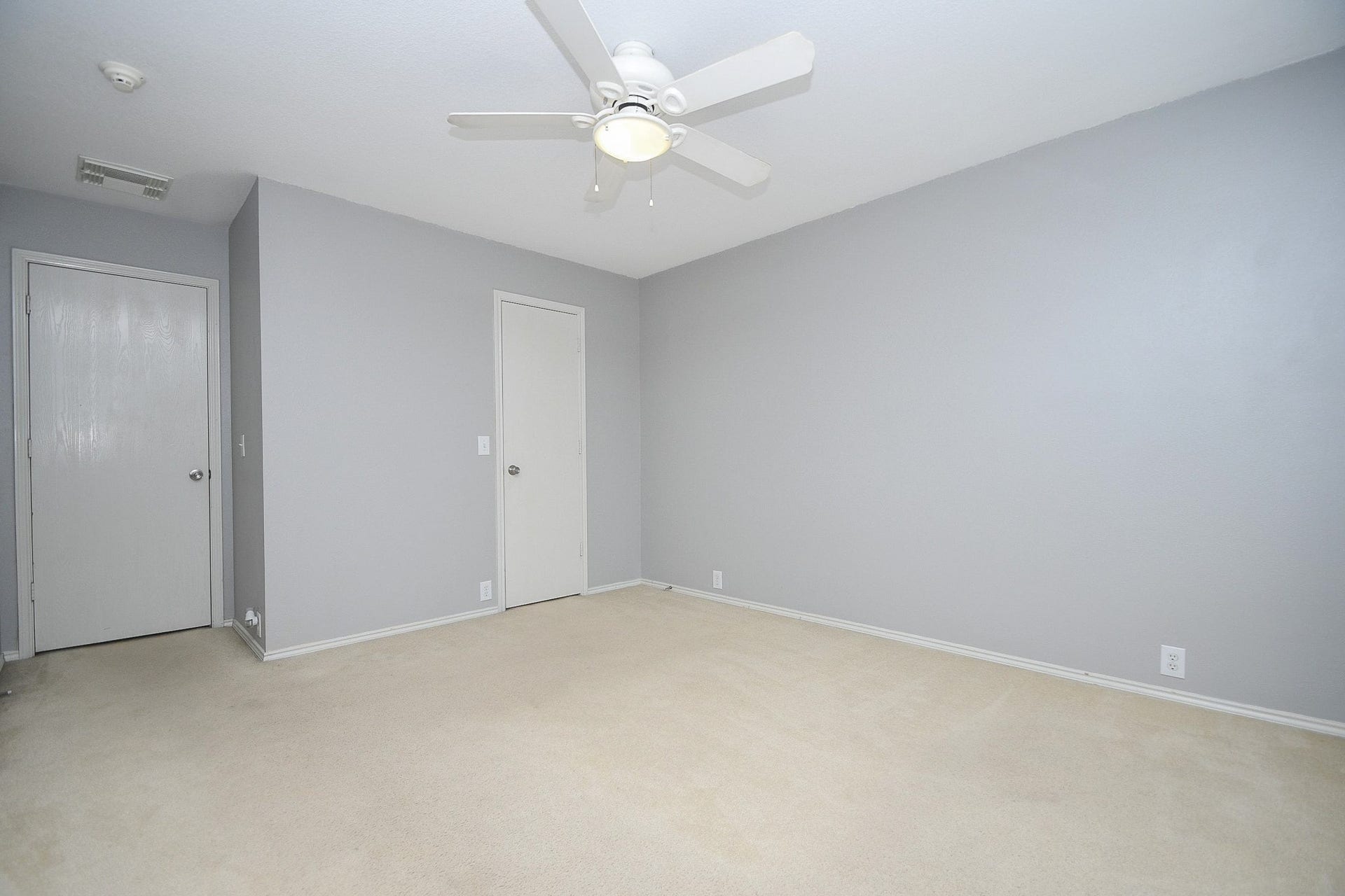 10222 Antelope Alley, Missouri City, TX 77459 Spacious bedroom with neutral tones, featuring a ceiling fan and plush carpeting, offering a serene and comfortable atmosphere.