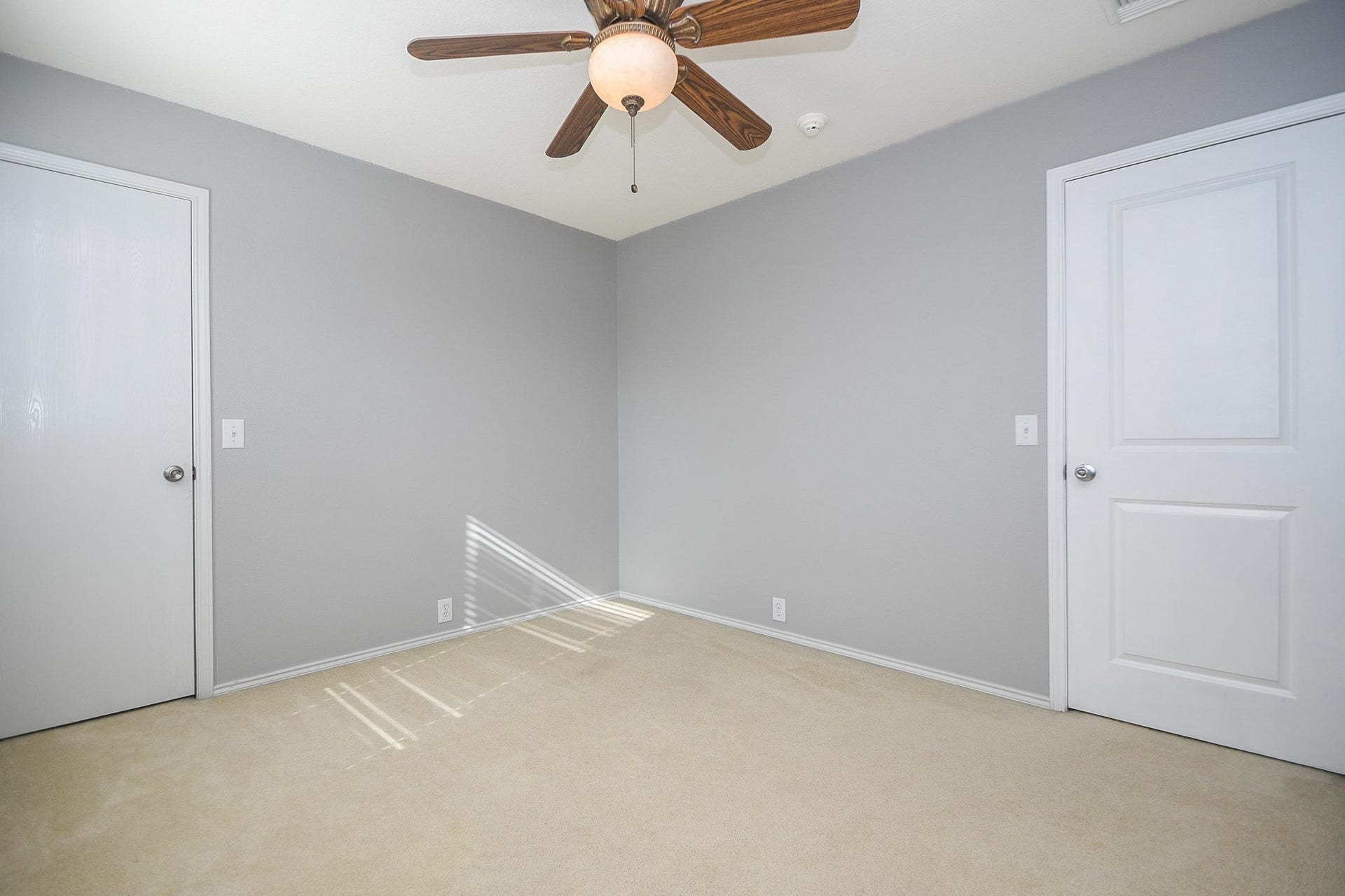 10222 Antelope Alley, Missouri City, TX 77459 Bright, neutral-toned bedroom featuring a ceiling fan, soft carpeting, and ample natural light from a side window.