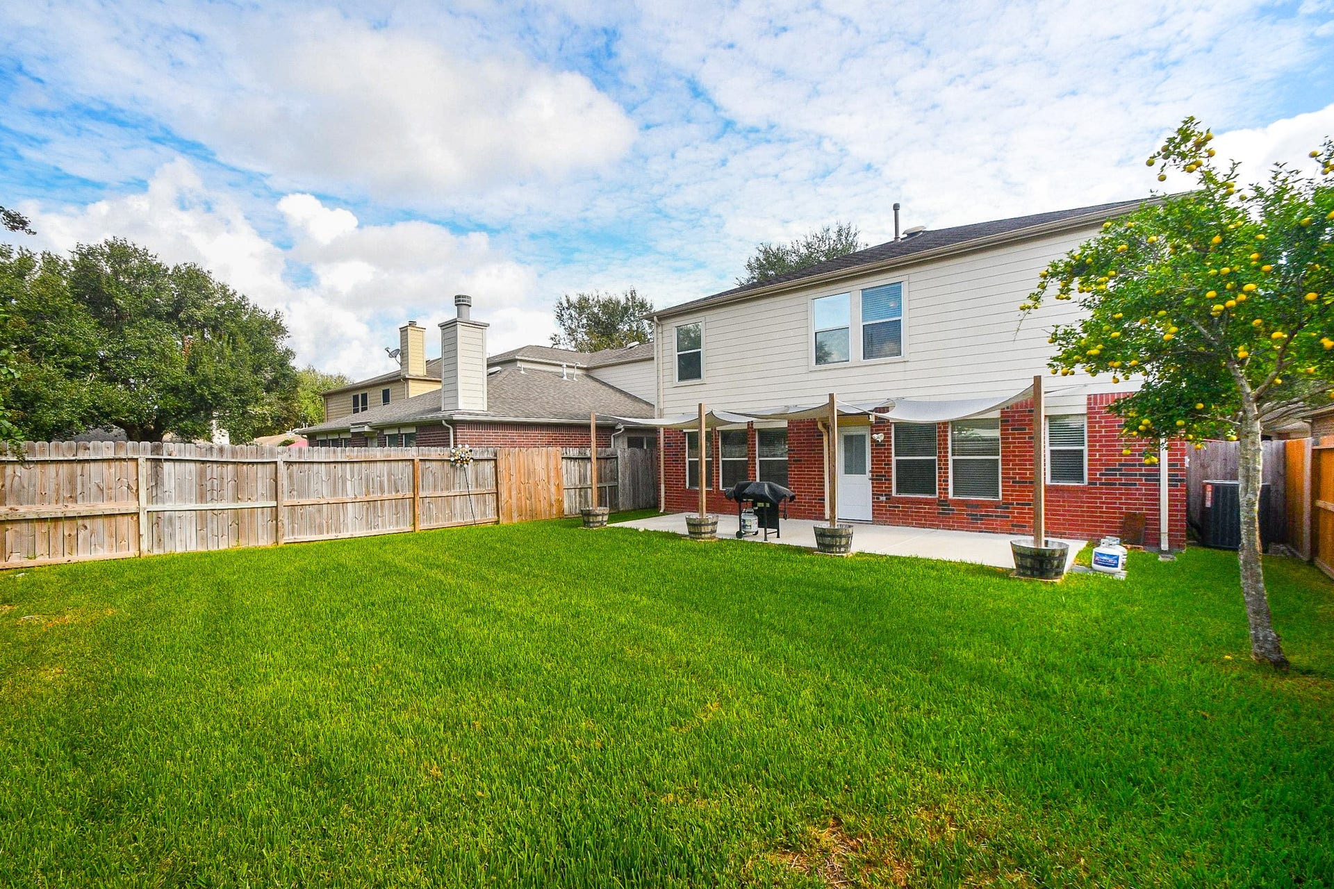 10222 Antelope Alley, Missouri City, TX 77459 Spacious backyard with lush green lawn, perfect for outdoor activities, complemented by a charming patio area for relaxation and entertaining.