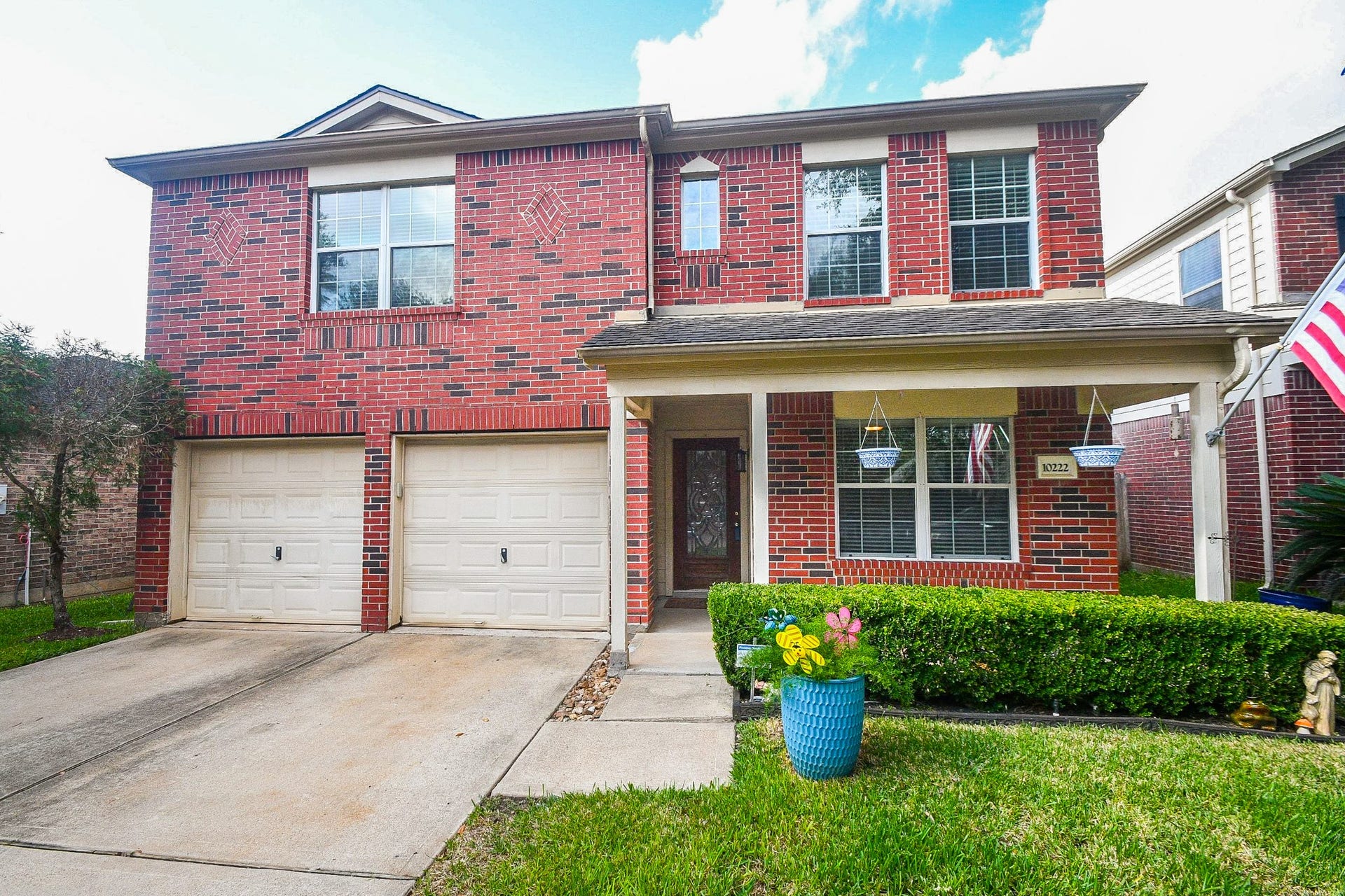 10222 Antelope Alley, Missouri City, TX 77459 Charming two-story brick home with a welcoming front porch, dual garage doors.