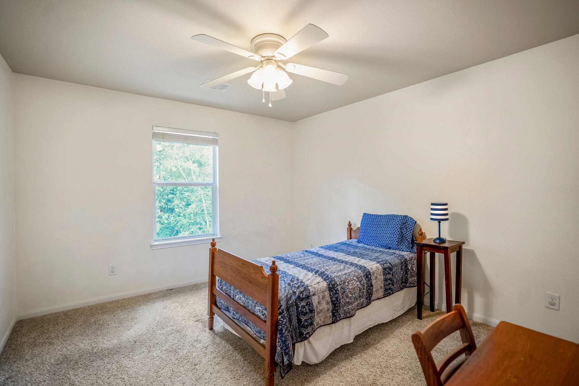 942 Oak Glen Drive, Conroe, TX 77378 The fourth bedroom continues the upstairs flow with new carpet, neutral walls, a ceiling fan, and a window bringing in natural light.